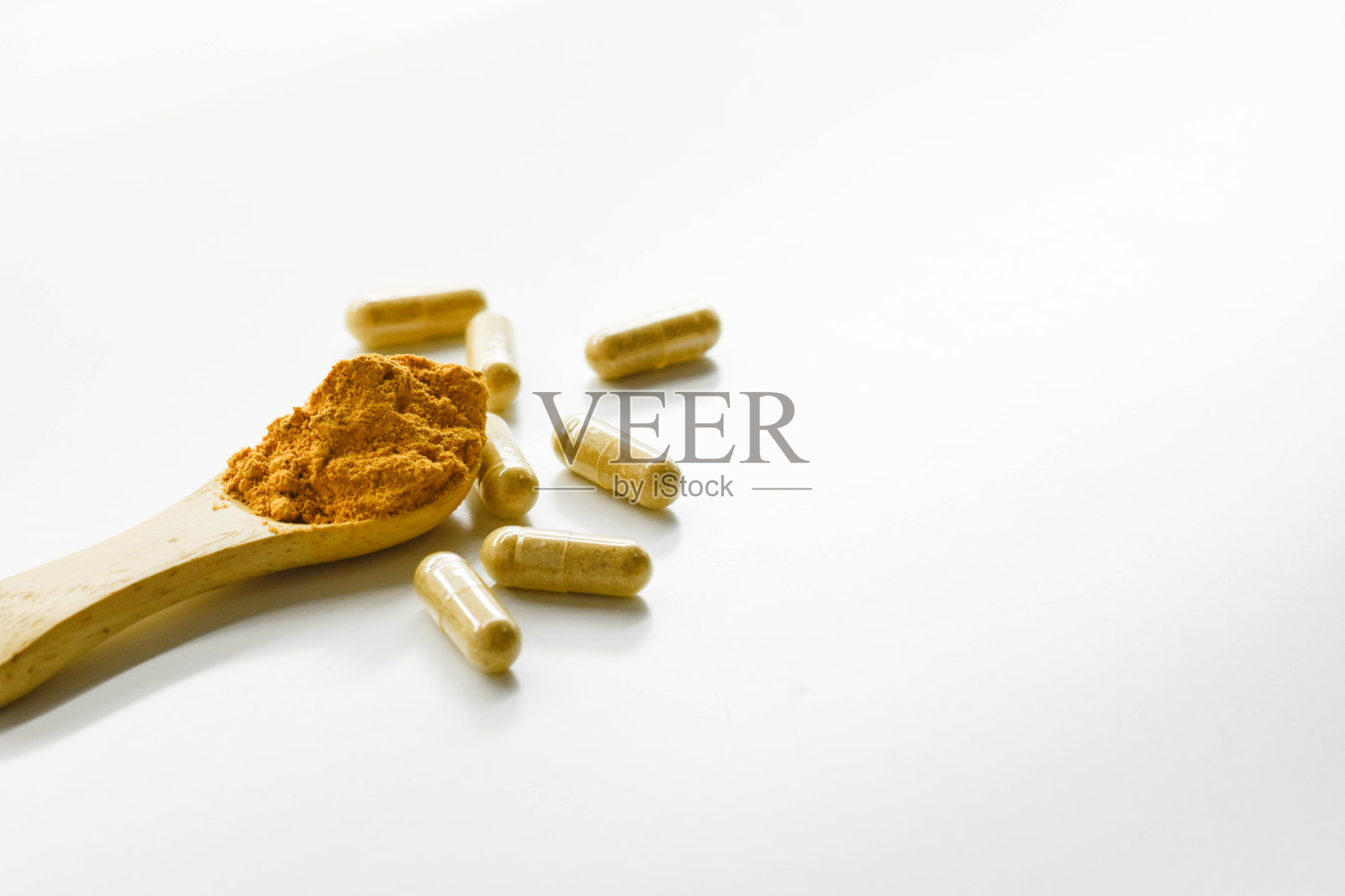 白色背景上的黄色胶囊。草药胶囊。照片摄影图片