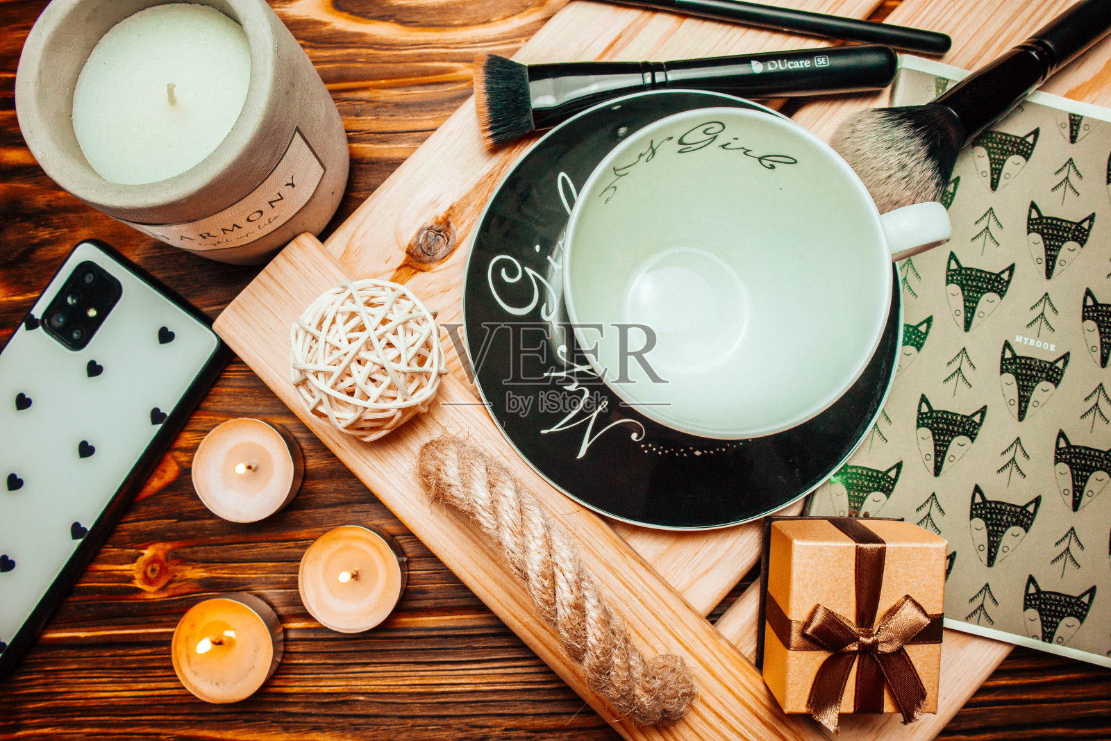 空杯子和电话在木棕色背景和托盘与蜡烛在春天。照片摄影图片