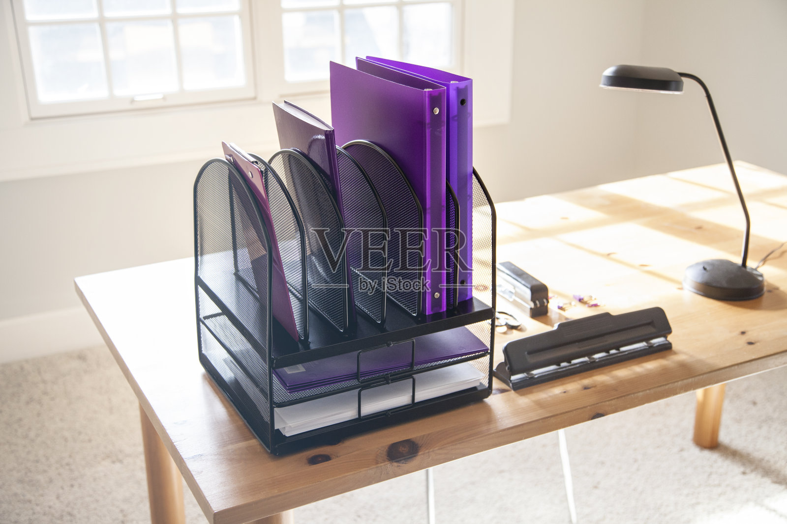 阳光家庭办公室木制办公桌和紫色文件夹照片摄影图片