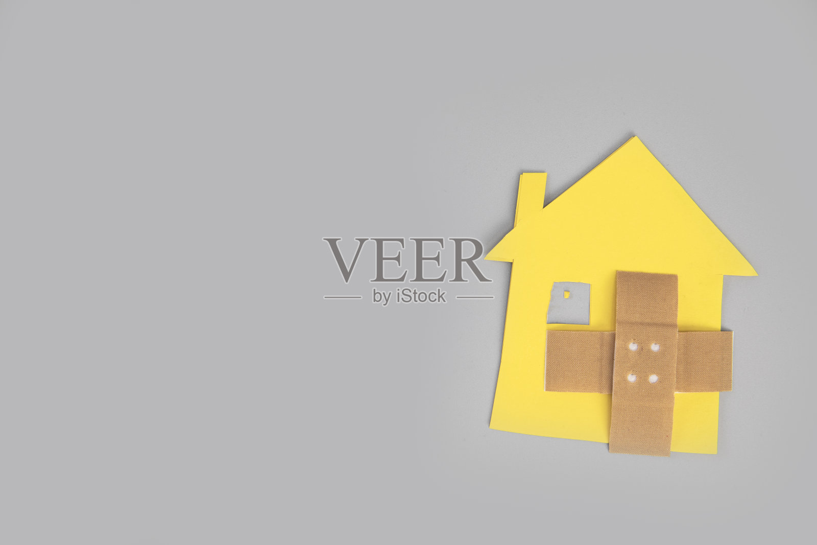 破碎的房子人物特写与交叉band aid在灰色背景顶视图，复制空间，离婚，关系问题，搬家，抵押贷款，照片摄影图片