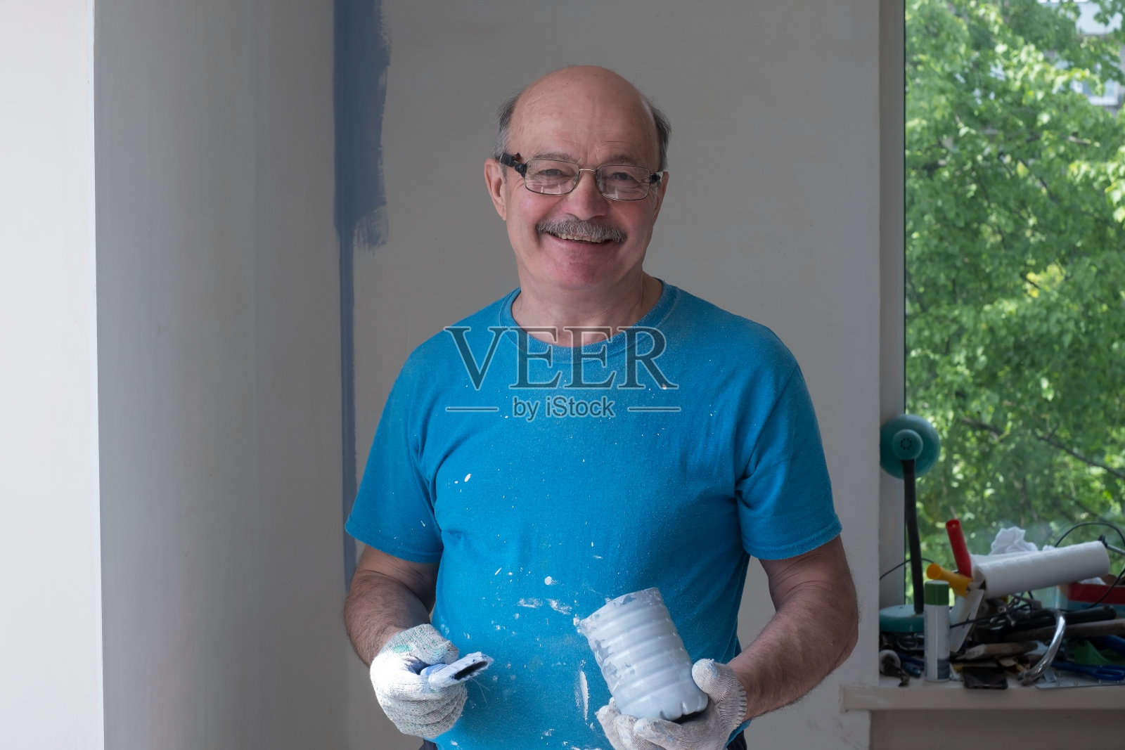 工人用刷子粉刷墙壁照片摄影图片