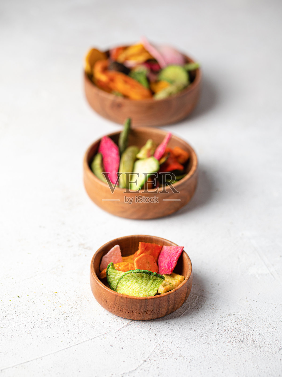 在一个木制芒果碗里脱水的素食薯条。照片摄影图片