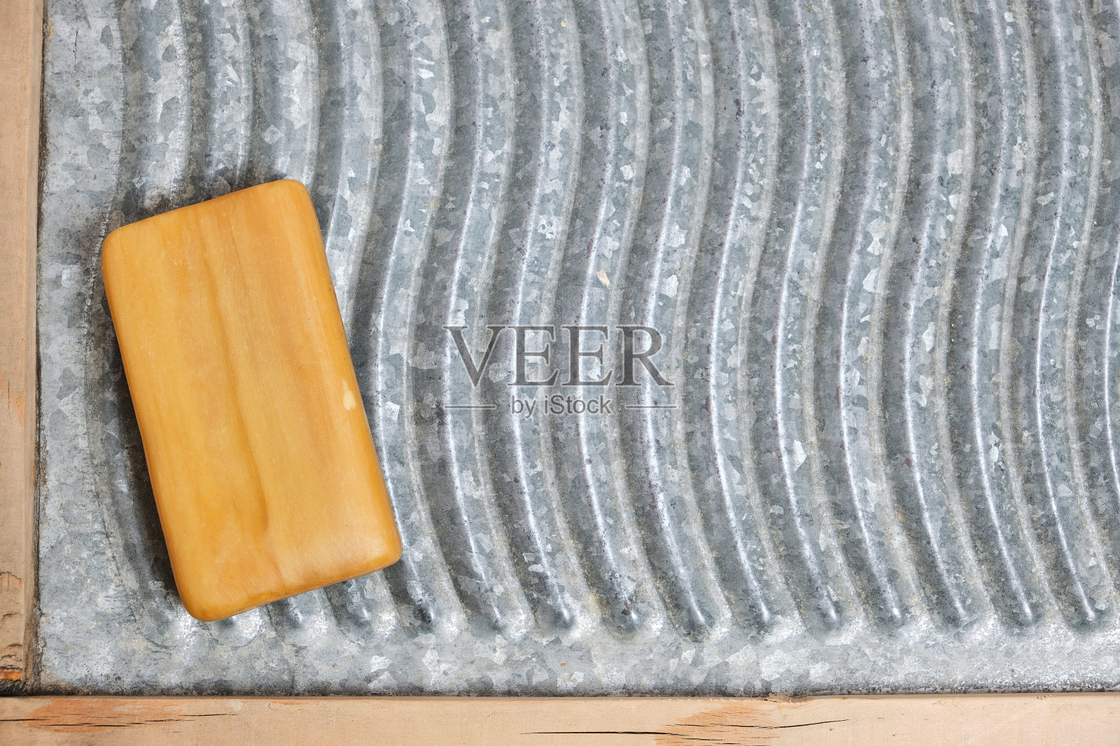 一块家用肥皂放在救济洗衣板上。照片摄影图片