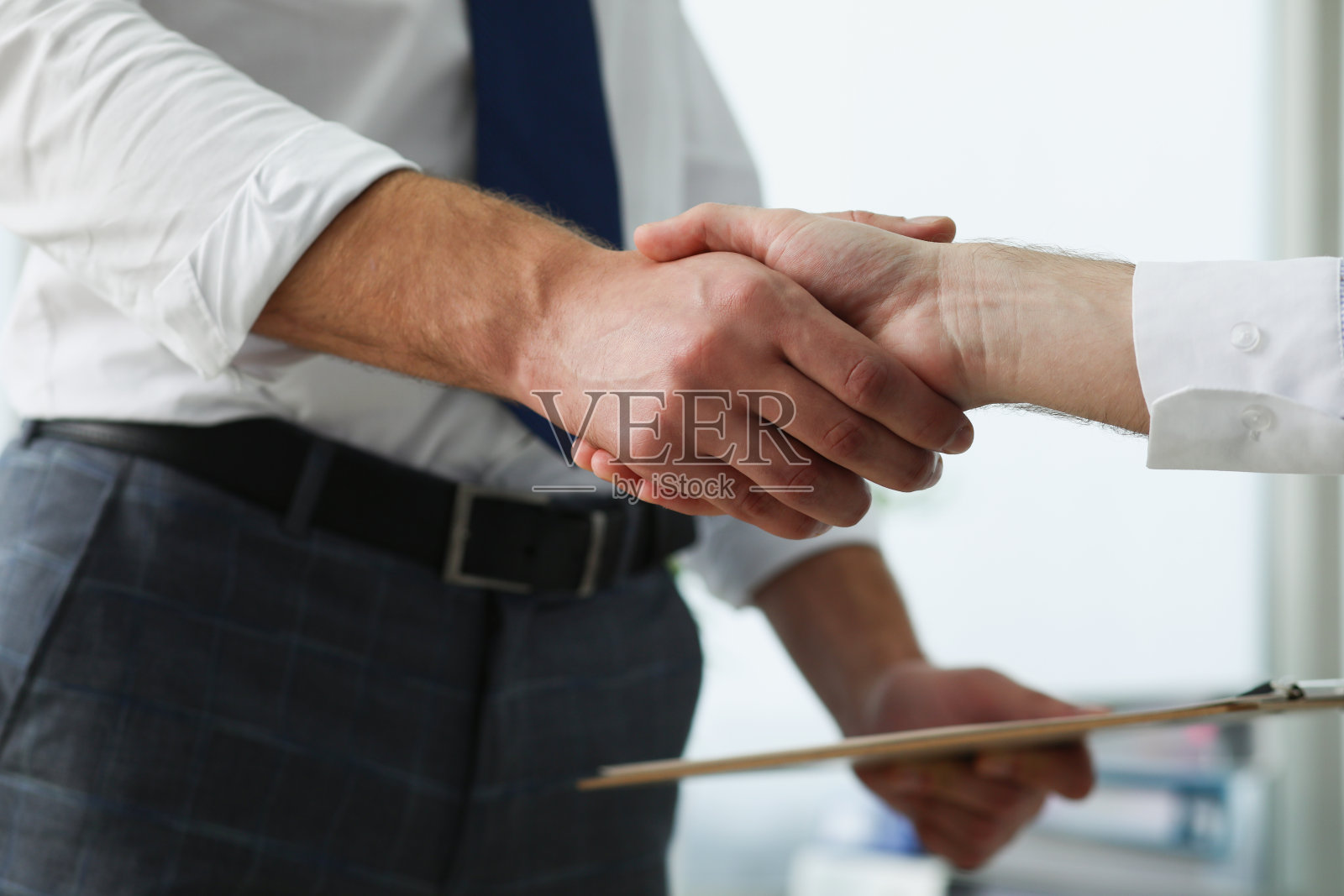 合伙人在办公室里握着商业剪贴板握手照片摄影图片