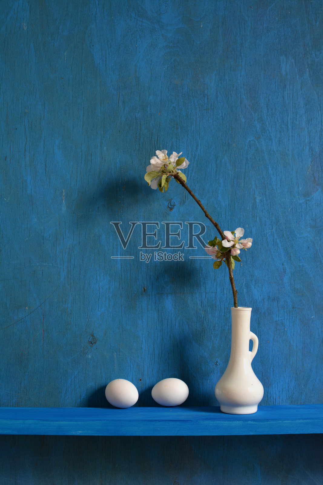 这是一幅苹果树开花的静物画，还有两个鸡蛋照片摄影图片