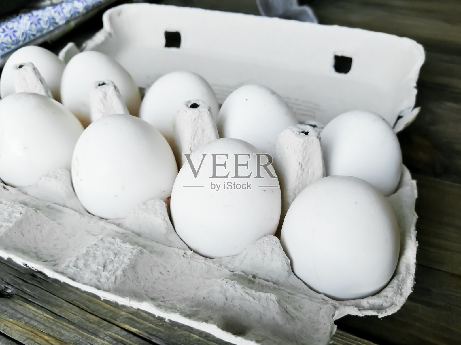 在托盘里自制的鸡蛋。木桌上的托盘里有10个鸡蛋。肮脏的鸡蛋。白色的蛋壳。照片摄影图片