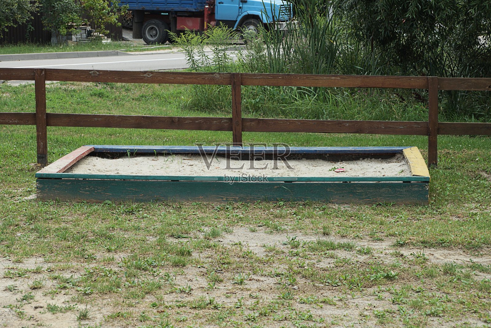 一个方形的木制沙盒，绿色的草地上有白色的沙子照片摄影图片