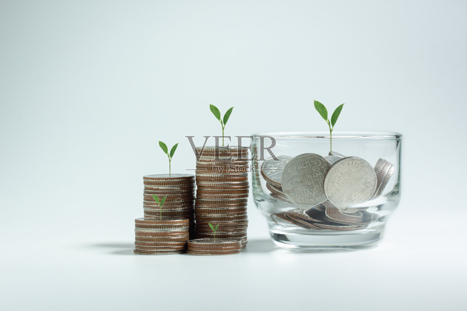 一个玻璃罐和堆叠的货币硬币和植物生长在顶部，用于商业，金融，会计，银行，储蓄，概念想法投资，债券，基金和交易营销概念。照片摄影图片