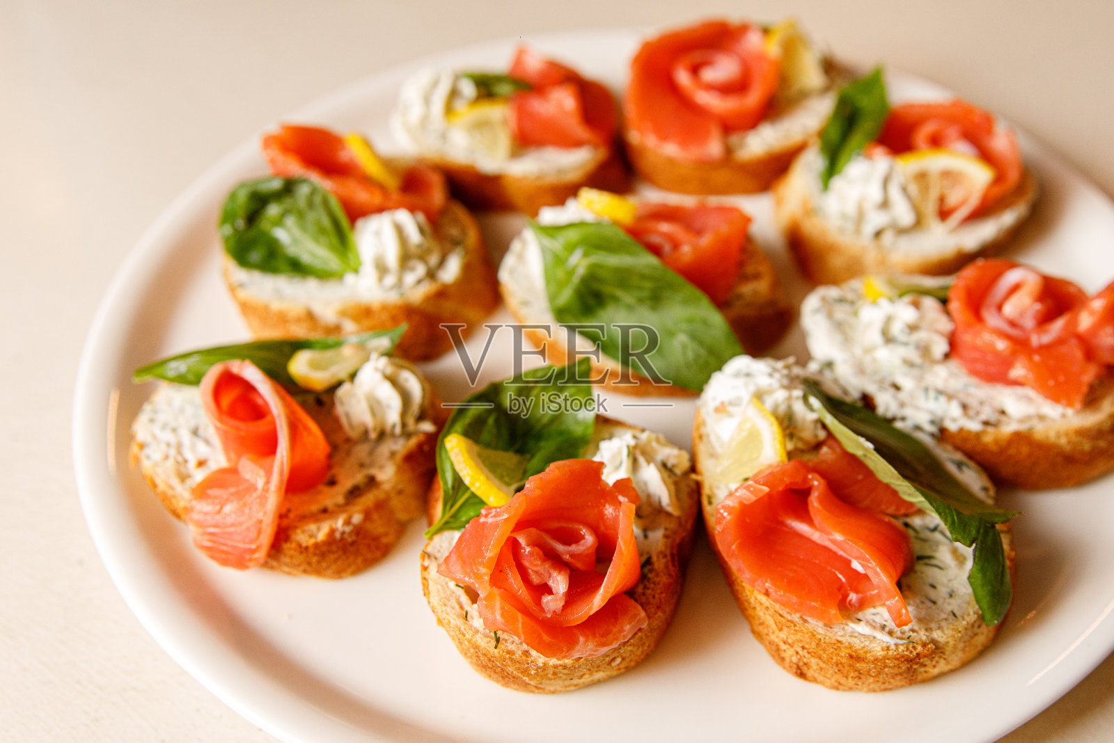 意式烤面包和三文鱼放在白色托盘上。照片摄影图片