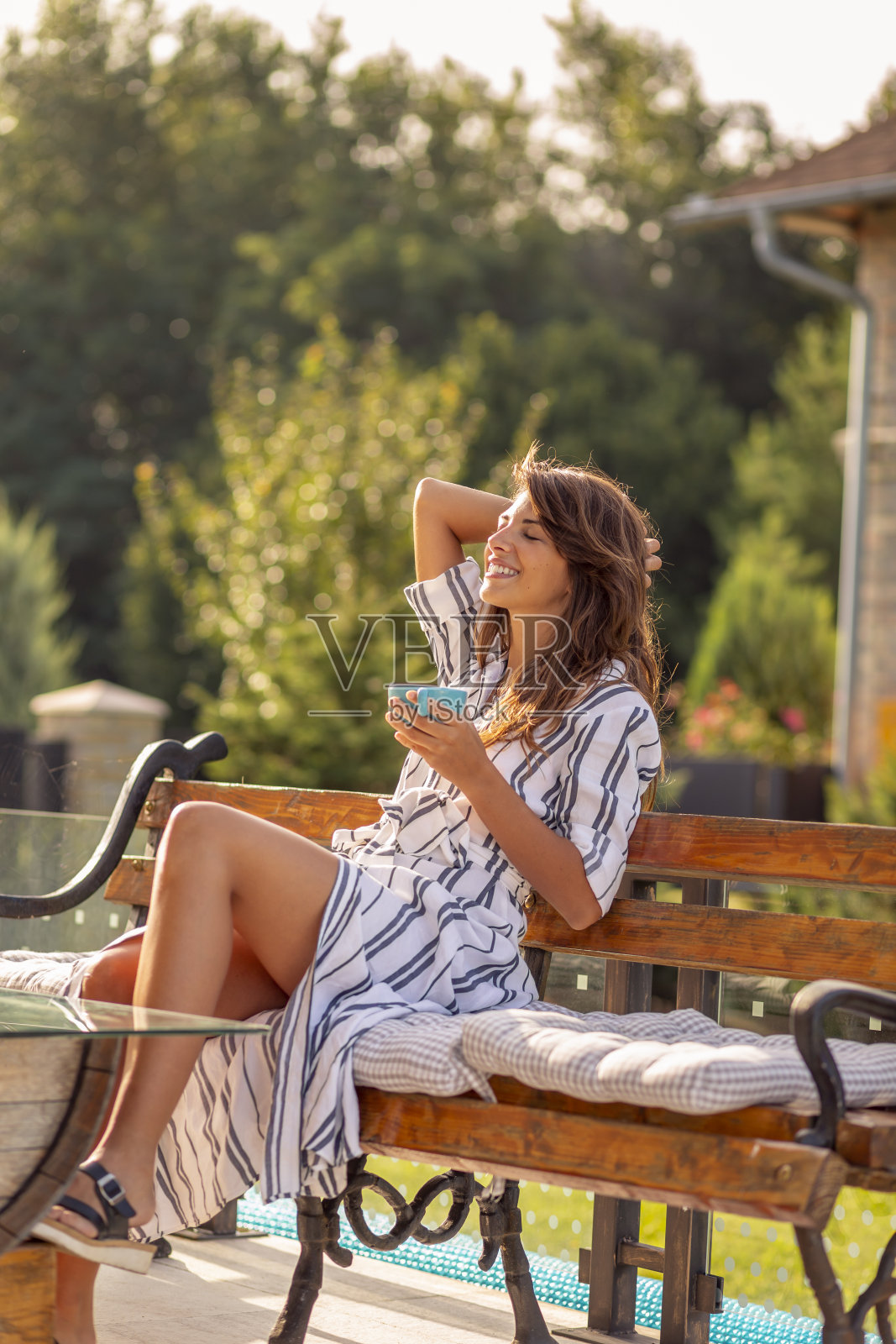 一个在花园里喝咖啡的女人照片摄影图片