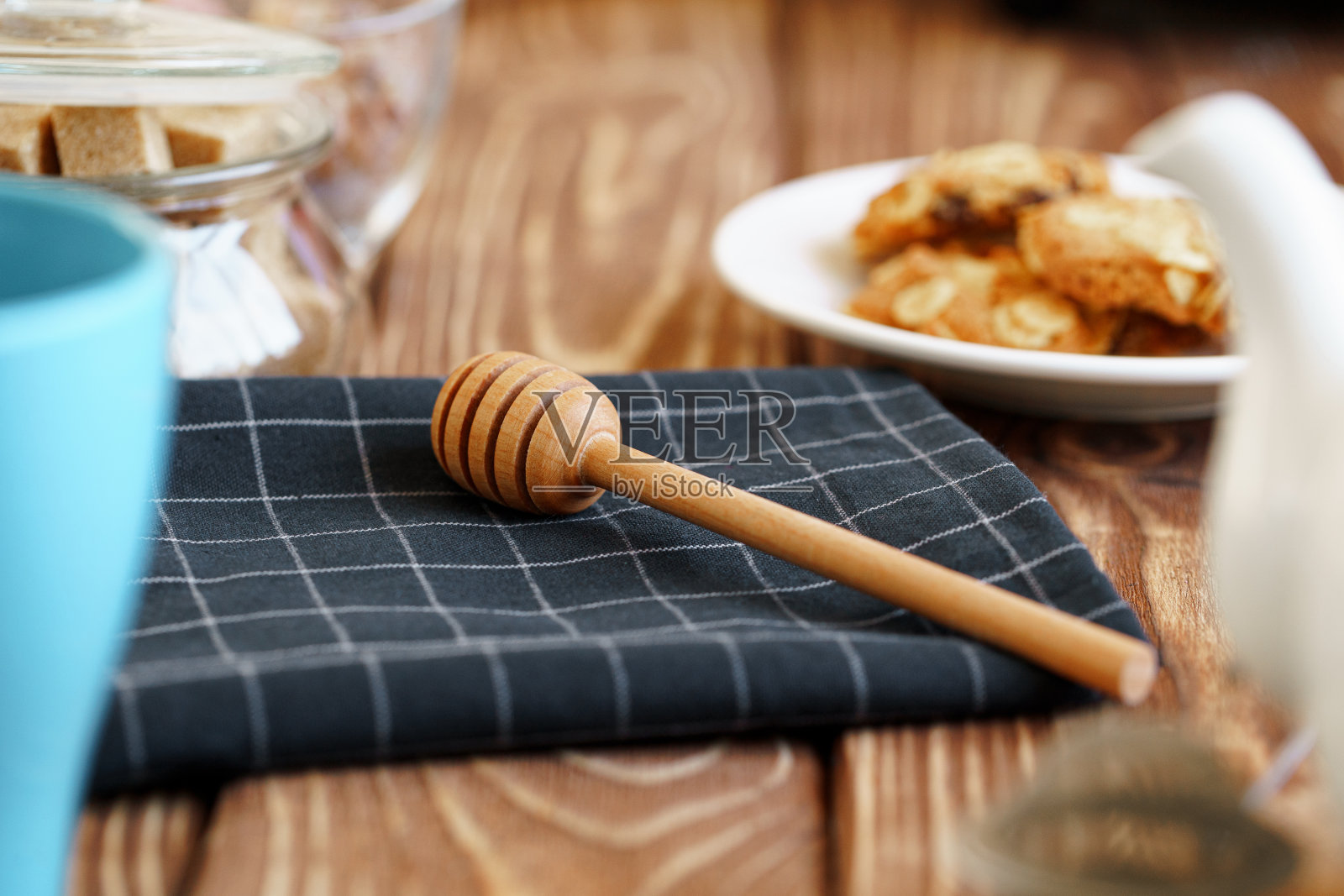 木制蜂蜜勺放在厨房的桌子上和厨房用具照片摄影图片