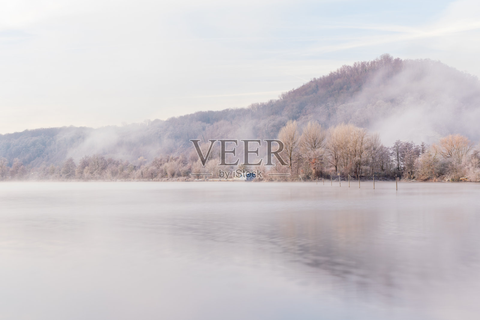 在一个初冬的早晨，马斯特里赫特山的日出与惊人的柔和色彩。这座山被雾笼罩着，创造了一个神奇的环境照片摄影图片