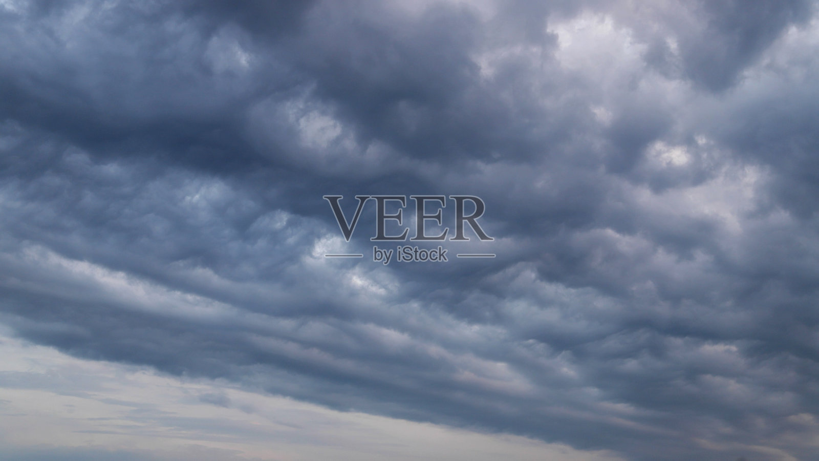 令人惊叹的蓬松的云漂浮在天空中，走向黑暗照片摄影图片