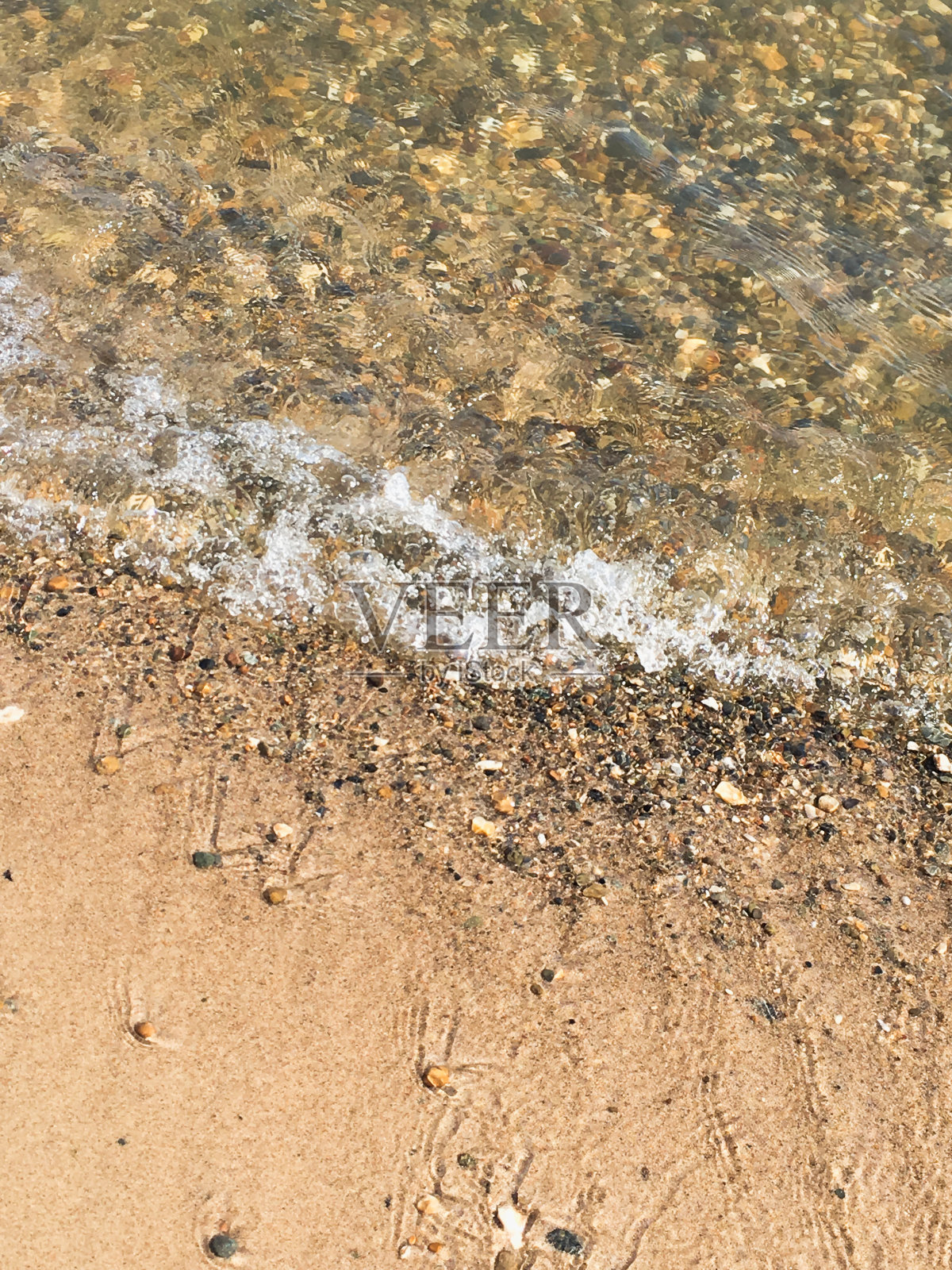 在沙滩上冲浪，沙滩上有鹅卵石照片摄影图片