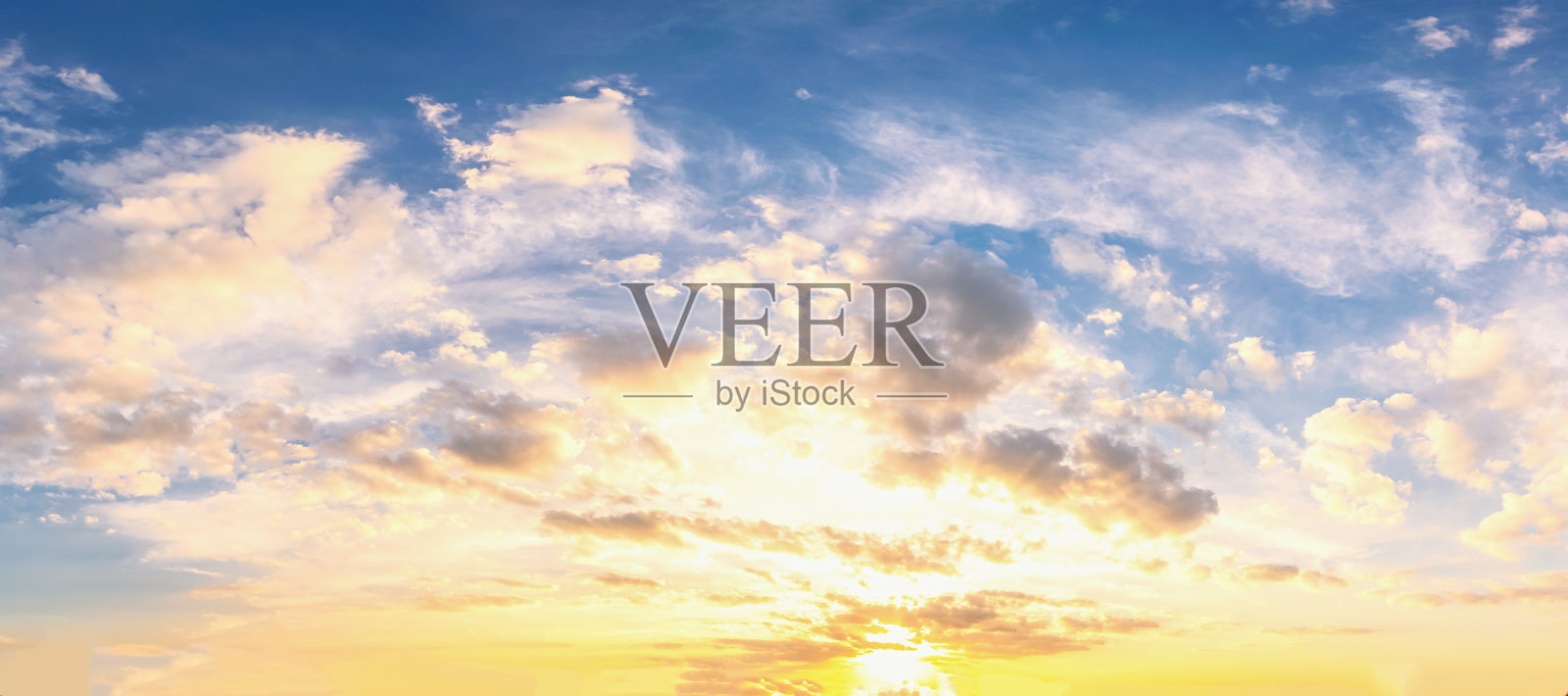 天空中蓝色和橙色的阳光透过云层照射在天空中照片摄影图片