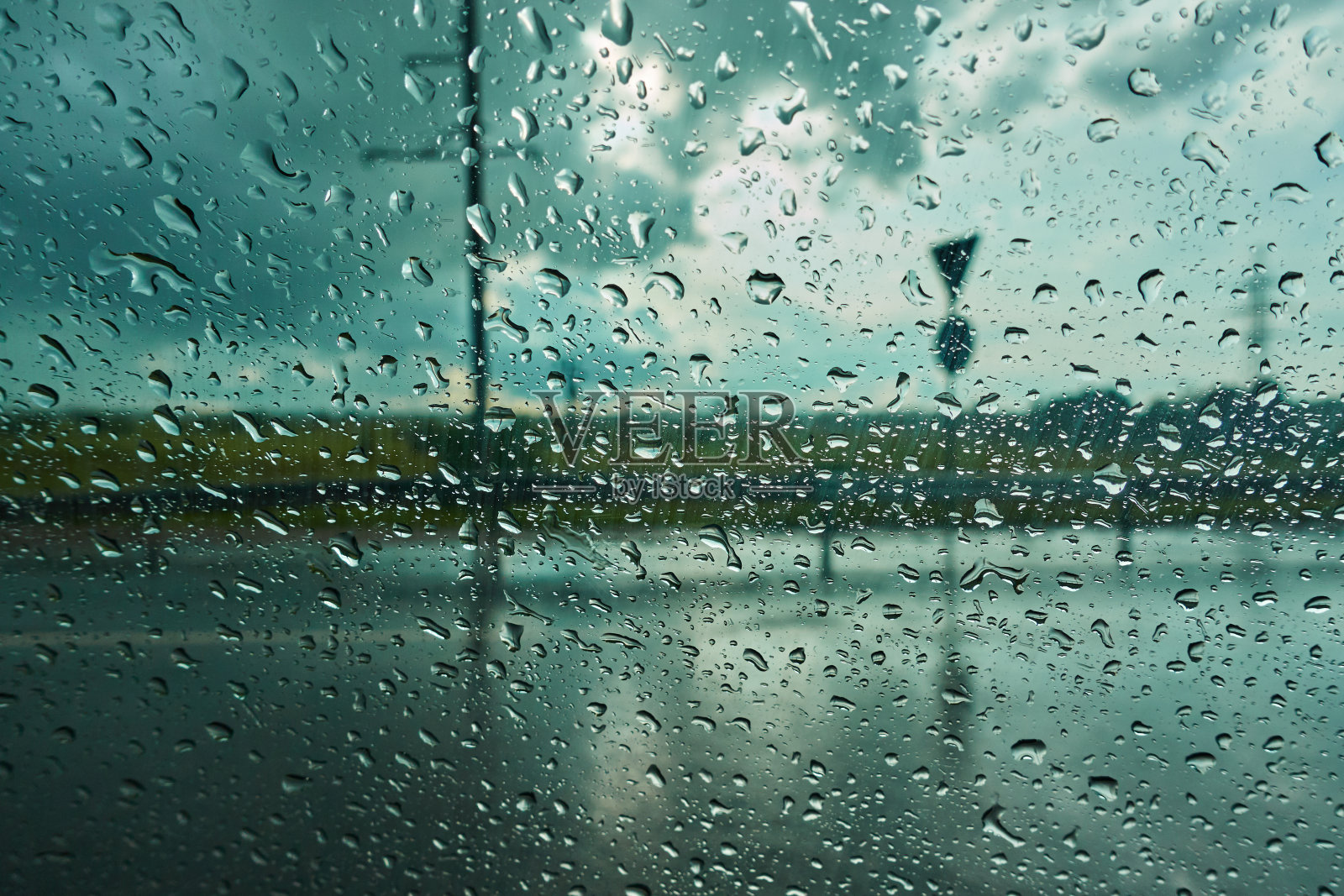 模糊的背景与雨滴在汽车玻璃上。在雨中骑行照片摄影图片