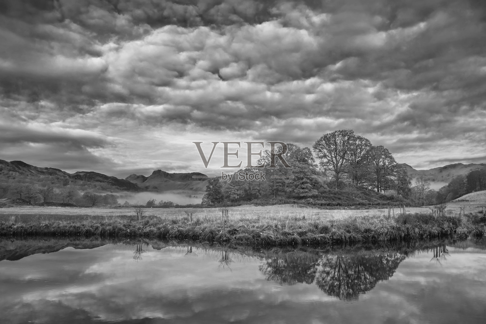 黑色和白色美丽的秋季风景图像在湖区的Brathay河，望向兰代尔派克河与雾和生机勃勃的林地照片摄影图片