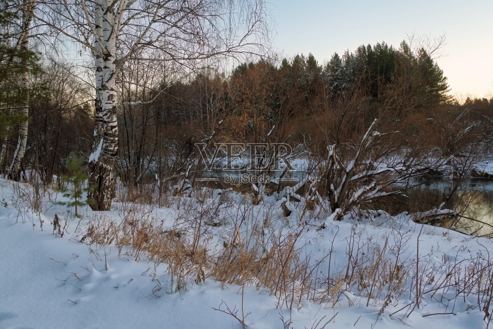 冬季景观森林河与桥在夕阳的背景。照片摄影图片