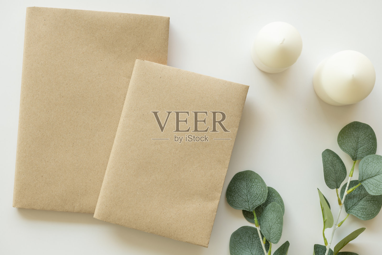 创意平铺照片的工作空间书桌。顶视图办公桌与样书，白色背景上的香薰蜡烛。工作空间的概念。俯视图，复制空间，模型，平躺。照片摄影图片