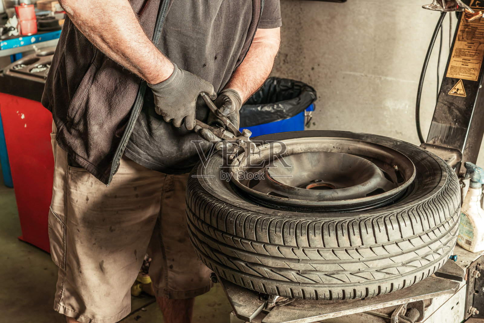 技工在车间里从轮子上取下导线照片摄影图片