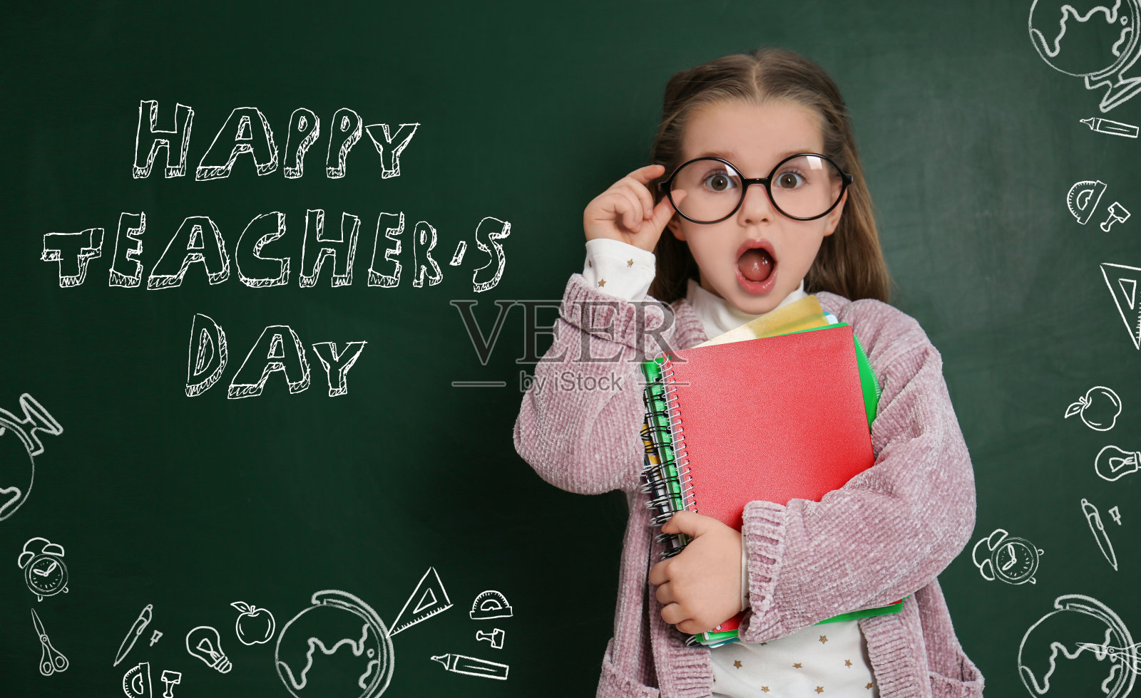 情绪激动的小孩戴着眼镜，靠近写有“教师节快乐”的黑板照片摄影图片