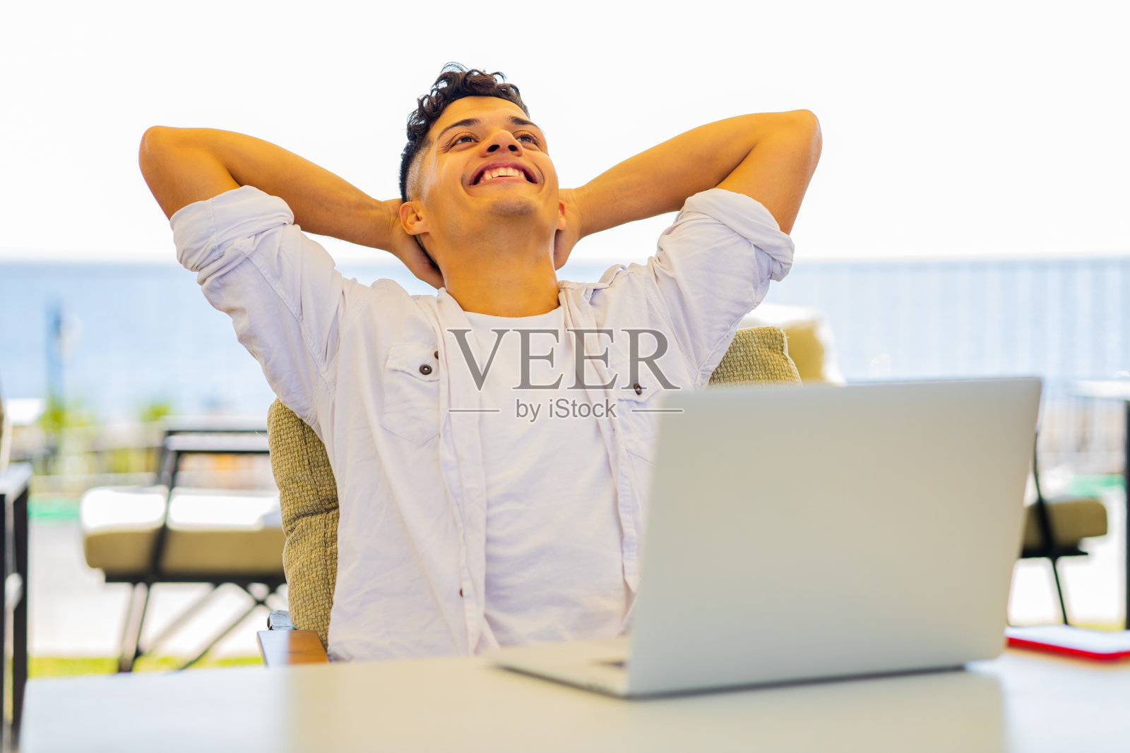 快乐的阿根廷学生在户外用笔记本电脑犯罪，看起来很高兴照片摄影图片