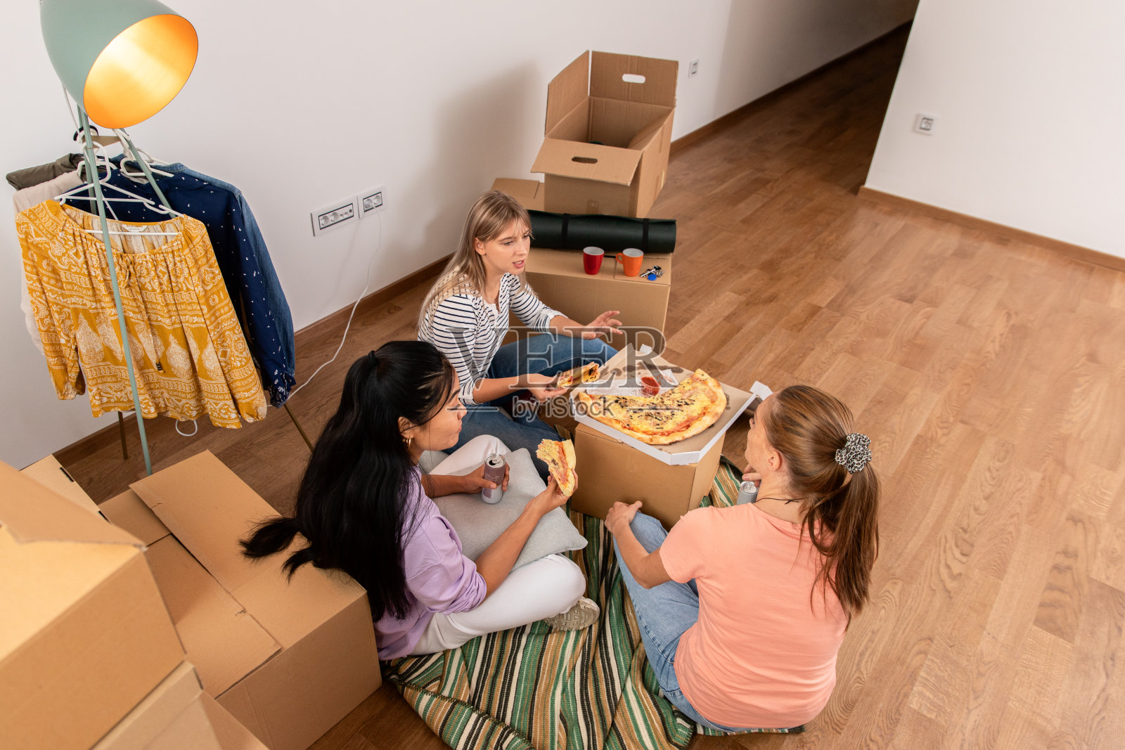 女性朋友朋友吃披萨后把盒子带进新公寓。照片摄影图片