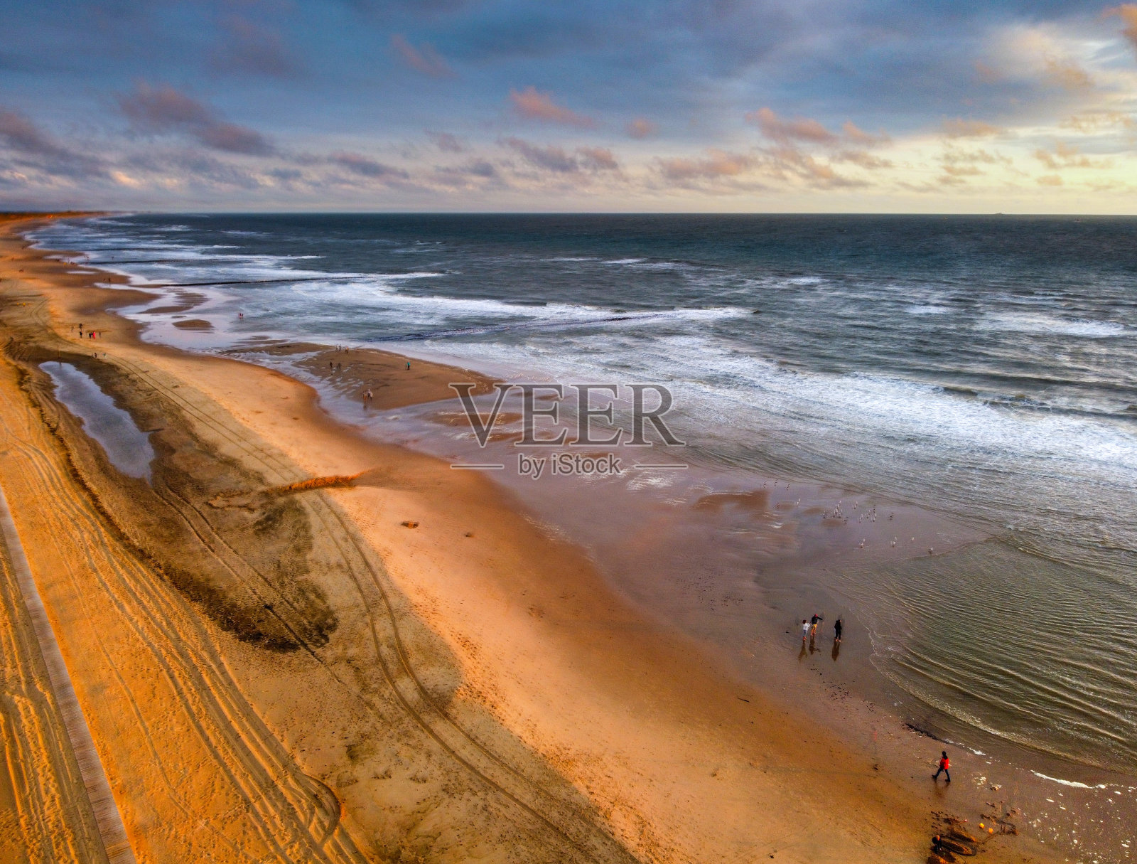 伴着海浪的海滩日落照片摄影图片