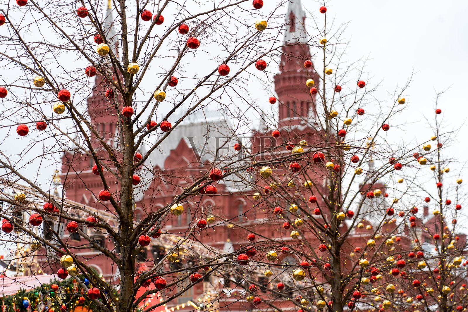 晚上喜庆金光，新年心情大气。城市街道上的节日彩灯。莫斯科大街上挂着红色圣诞球的树枝。照片摄影图片