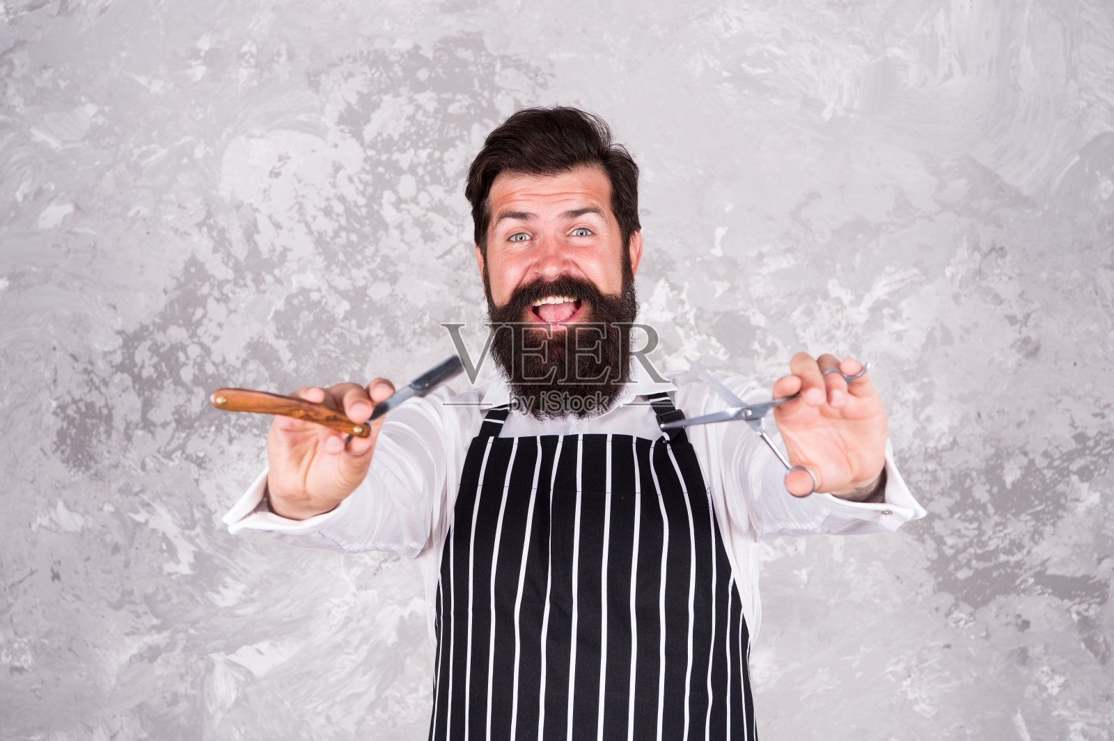 理发工具。理发师在围裙理发师设备刀片和剪刀。快来理个专业发型。理发店的主人。老式的理发师。好好护理面部毛发。有胡子的潮人剃须照片摄影图片