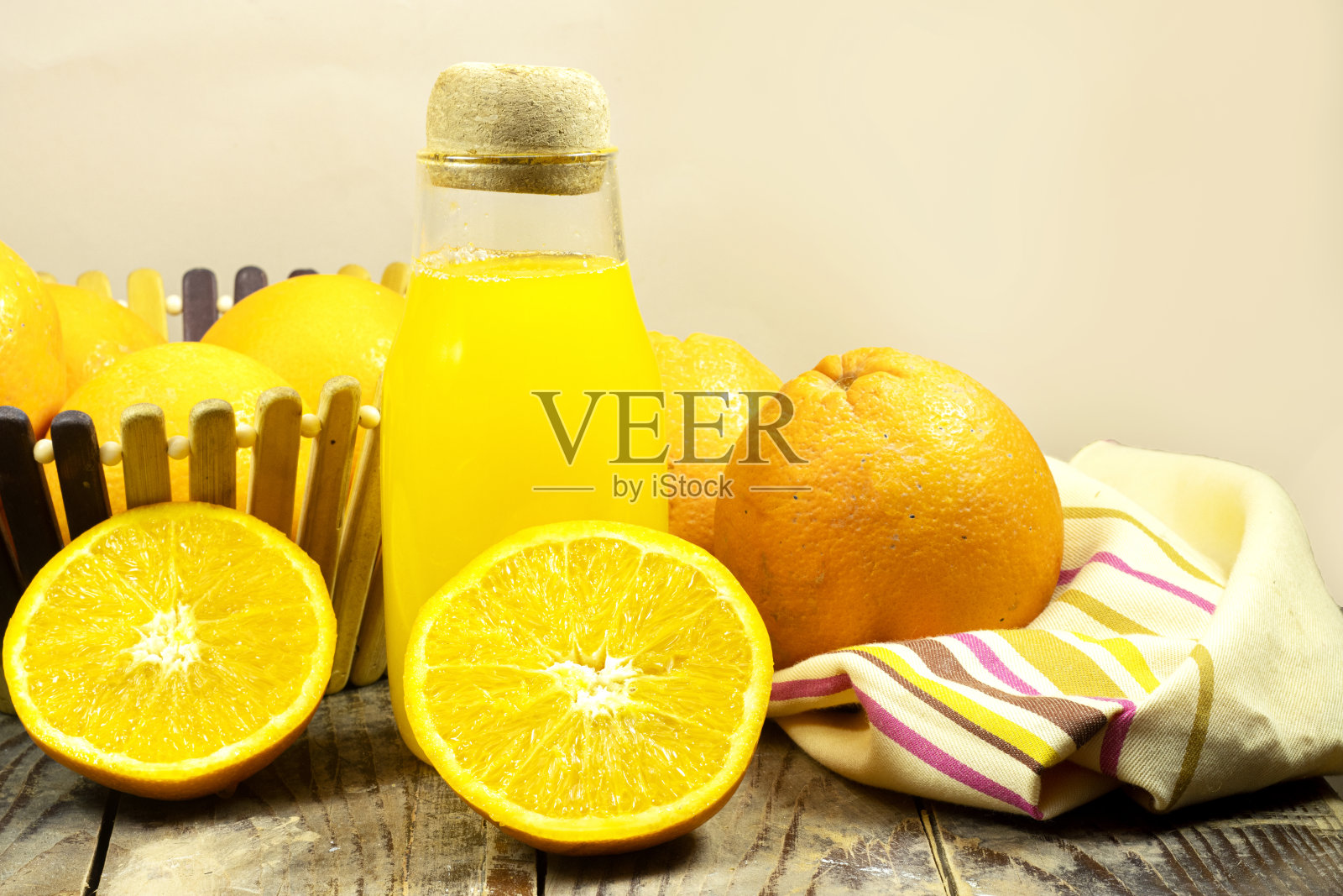 玻璃瓶的新鲜橙汁和新鲜水果在篮子里在木板桌子上照片摄影图片