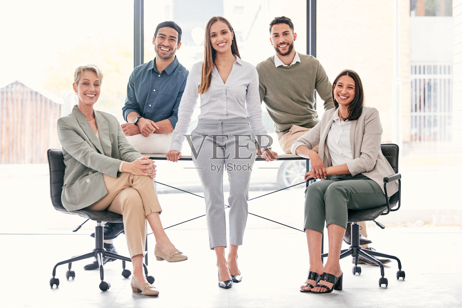 全天，一群不同类型的商人坐在办公室里照片摄影图片