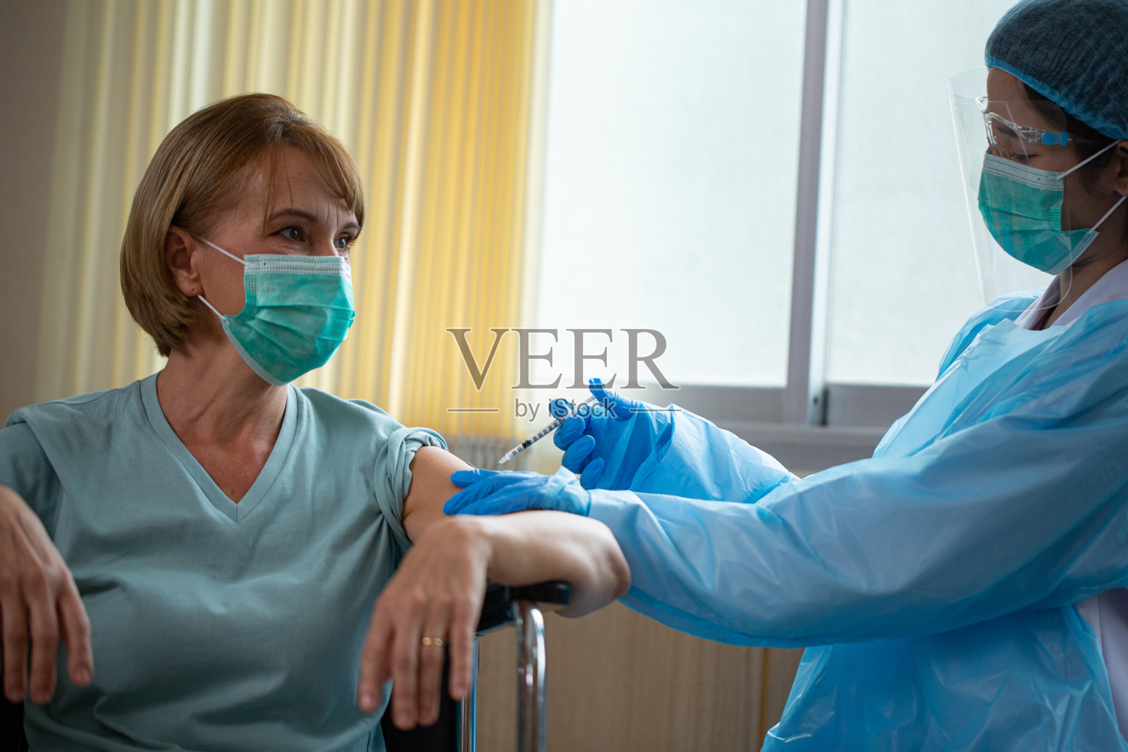 医生准备给老年病人注射的疫苗照片摄影图片