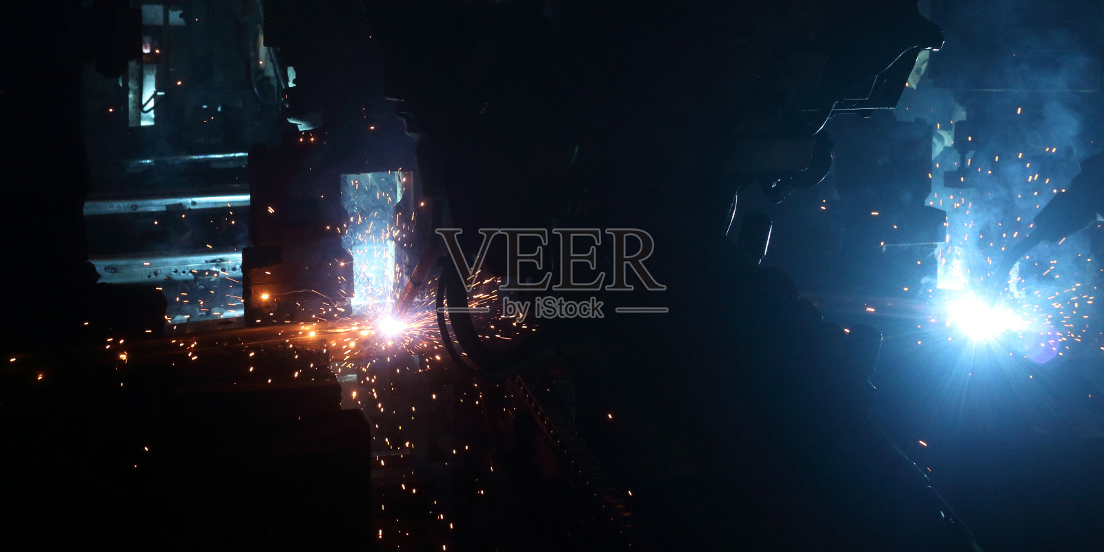 汽车零部件工业中焊接机器人的运动，汽车零部件工厂中焊接机器人的运动。照片摄影图片