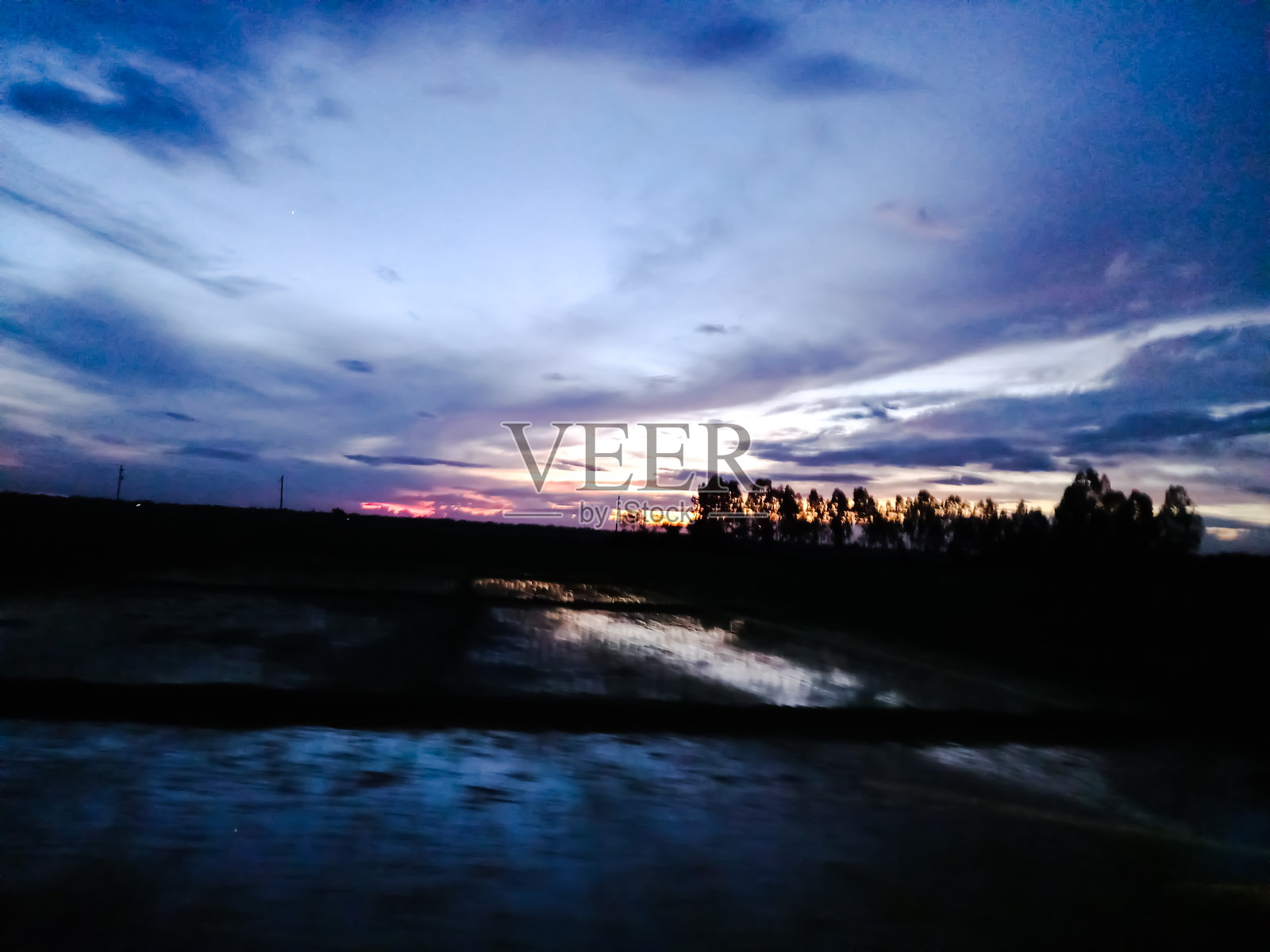 日落在村庄。自然景观。自然在孟加拉国。倒影，蓝天和日落后的灯光。在日落之后景观。照片摄影图片