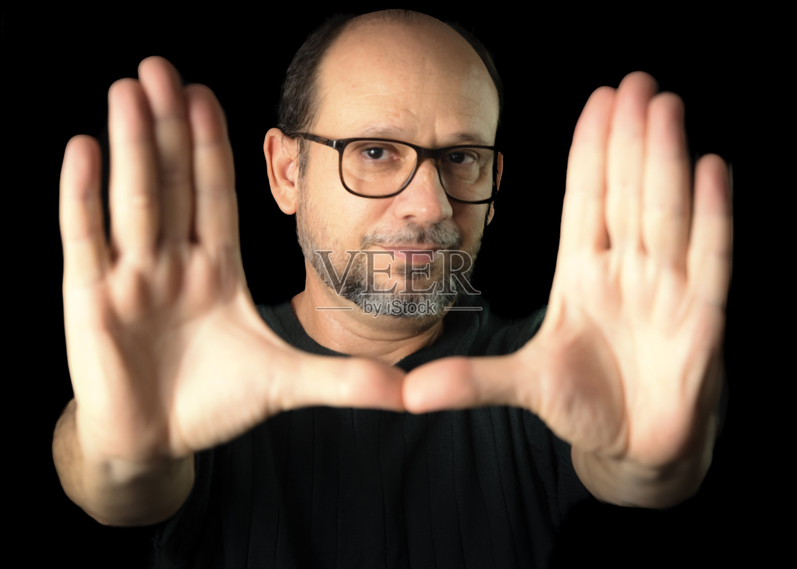 一个戴着眼镜的大胡子男人的肖像，背景是黑色的。照片摄影图片