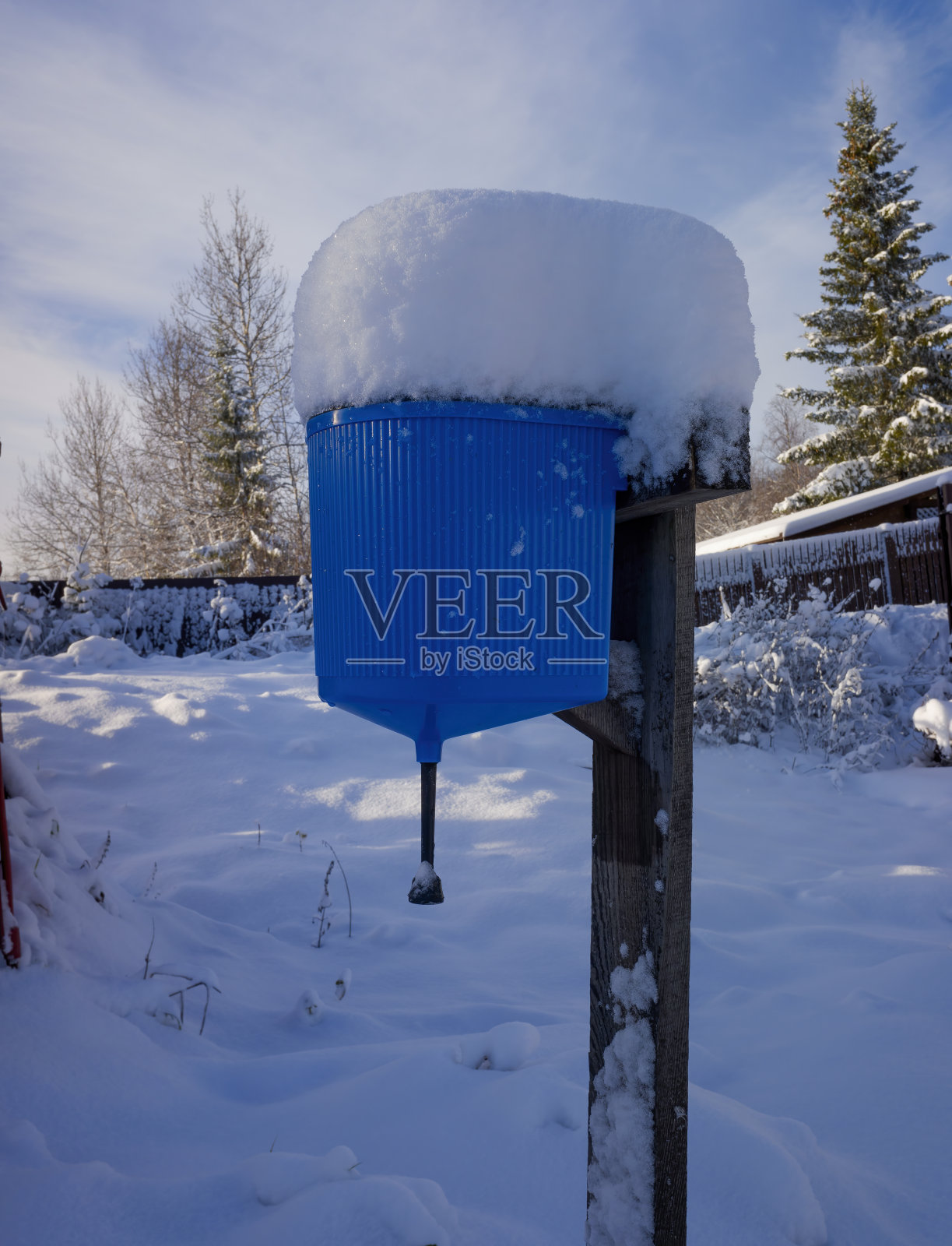 乡村房子的街道上的蓝色脸盆从上面覆盖着雪。第一场雪落在城外照片摄影图片