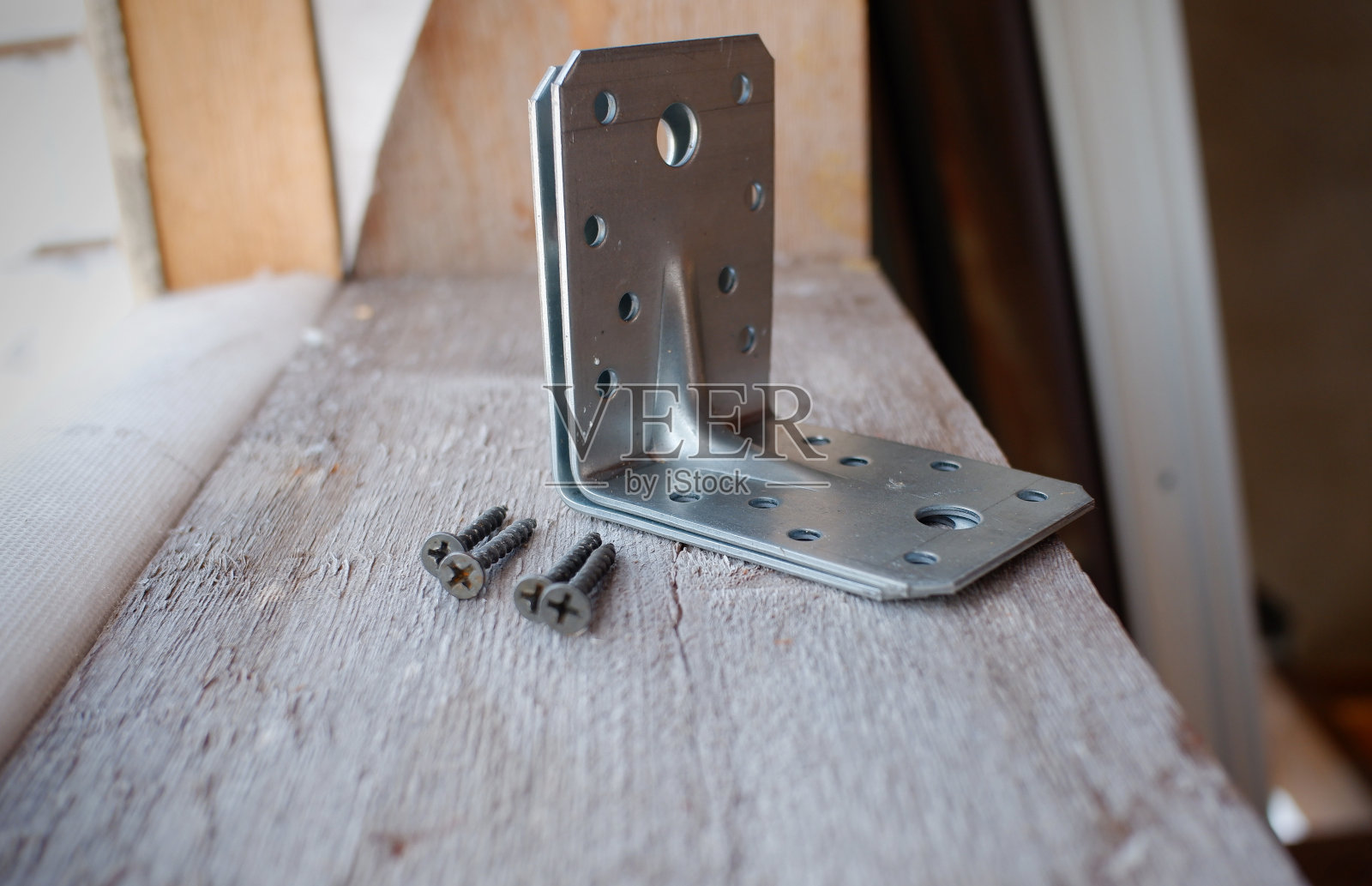 一座在建房屋的窗台上放着一个金属角和螺丝，照片摄影图片