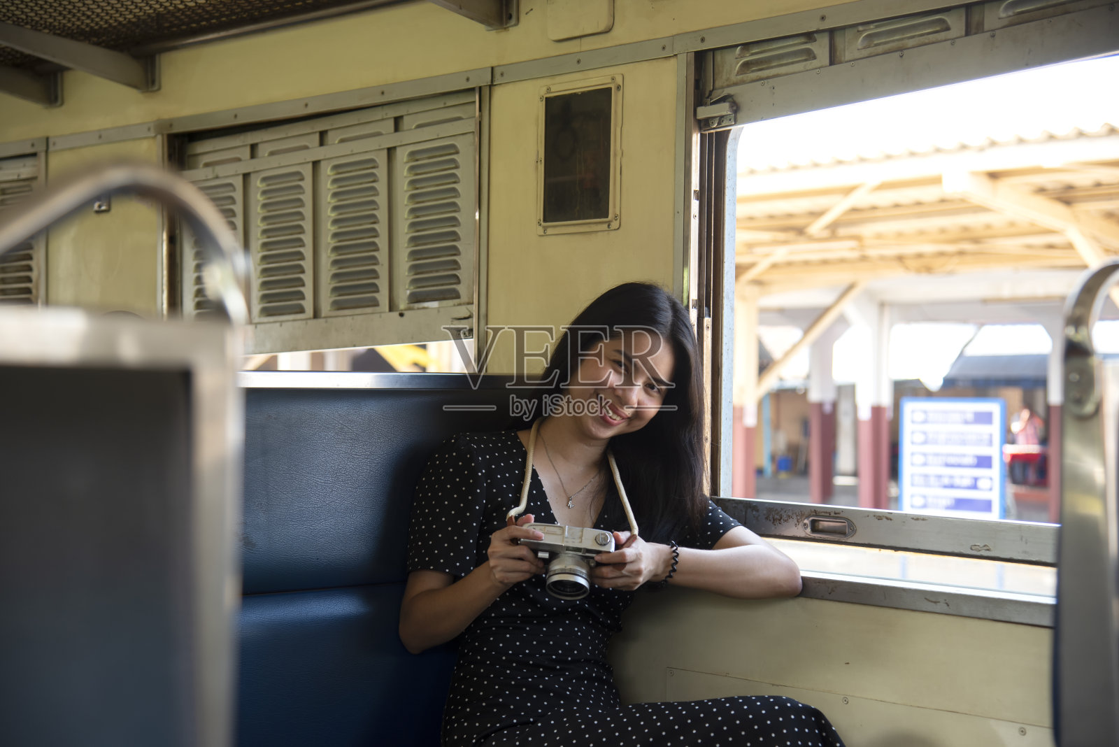 年轻的亚洲妇女微笑的旅行者女孩走着，在站台上等待火车照片摄影图片