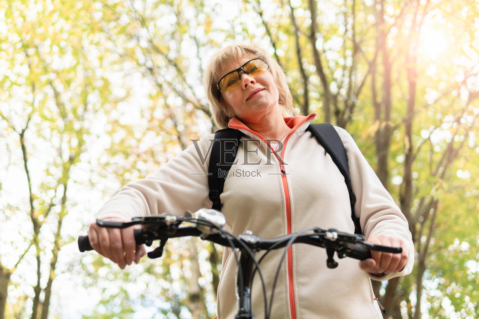 一个女人骑自行车在城市公园的道路上照片摄影图片