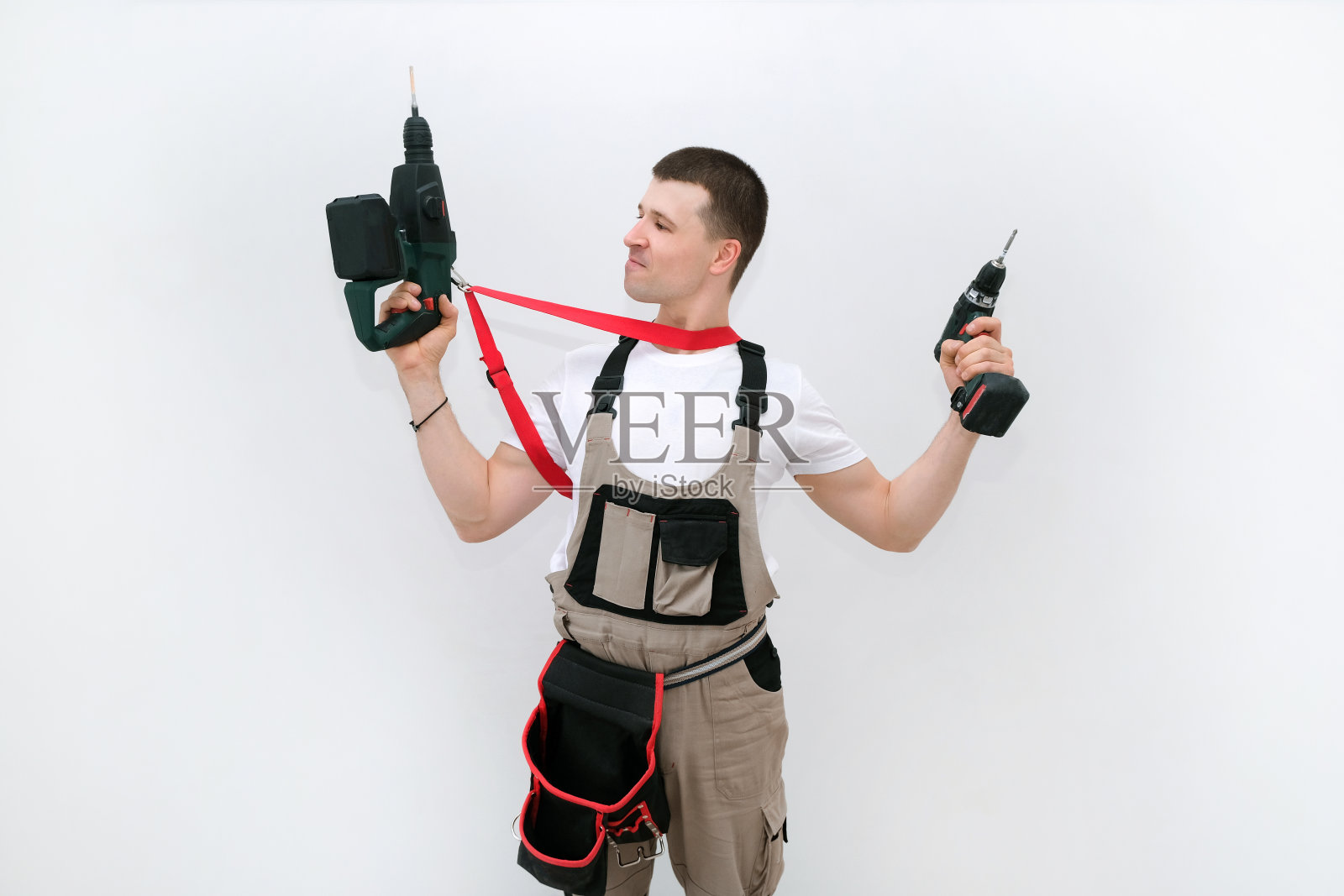 工人手里拿着锤子钻和螺丝刀照片摄影图片