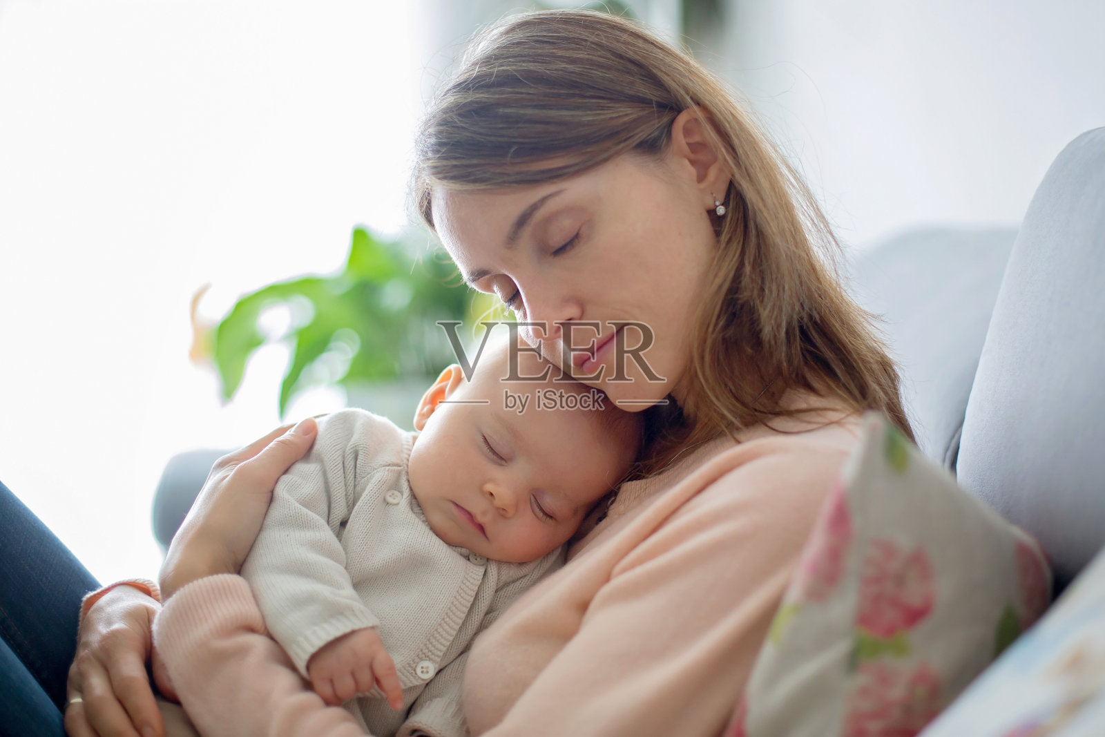 年轻的母亲，温柔地抱着她刚出生的儿子照片摄影图片