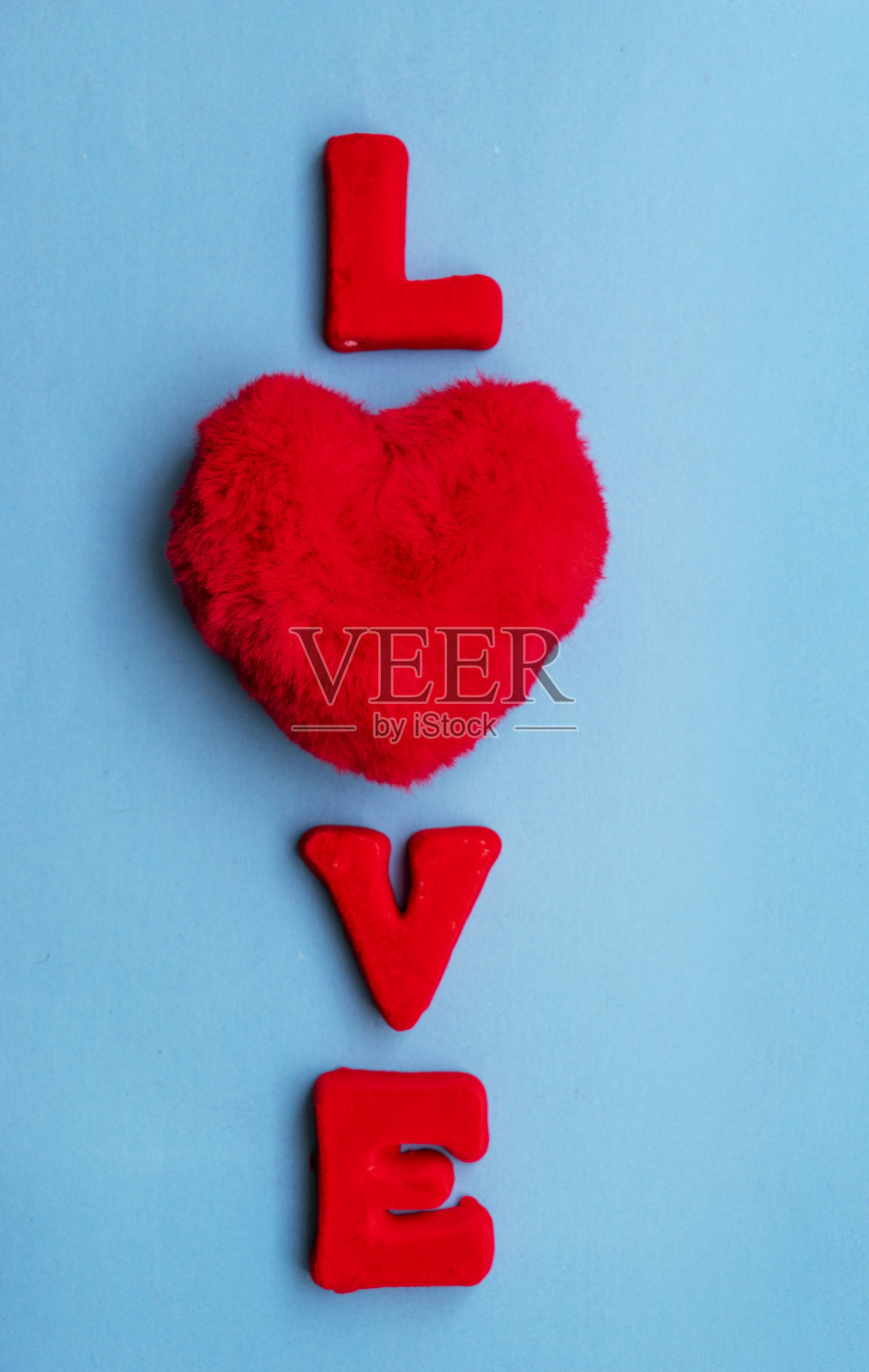 Love这个词是由蓝色背景上的红字组成的。照片摄影图片