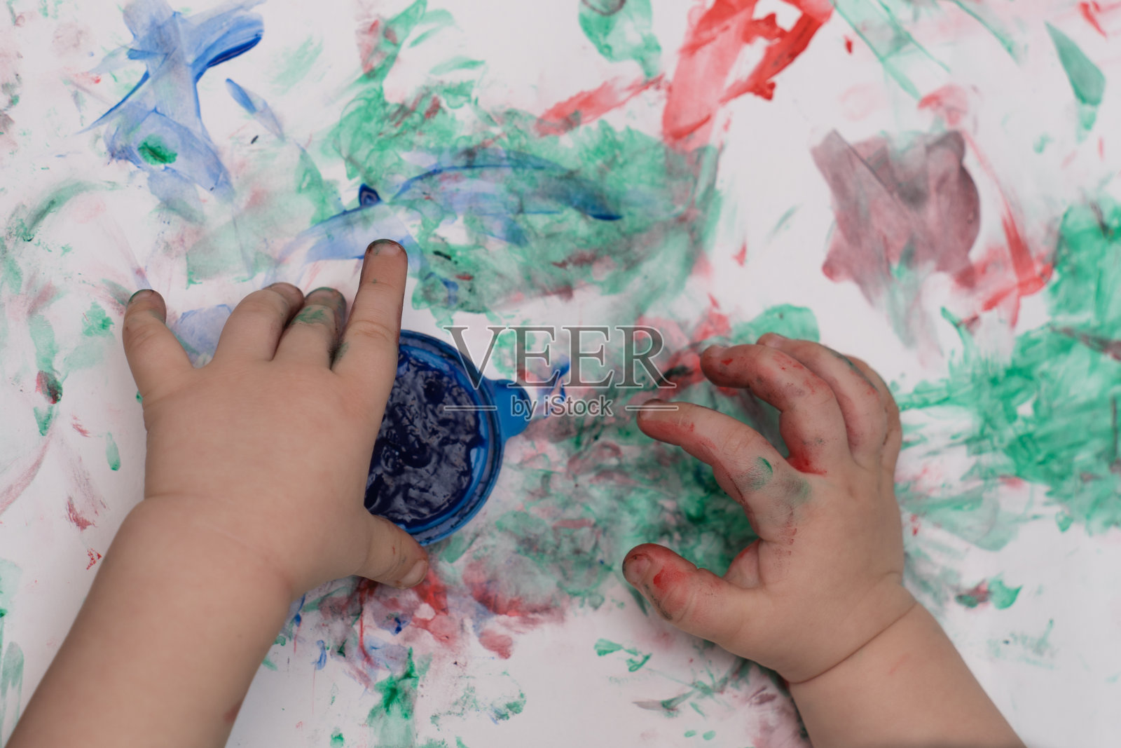 孩子的手用颜料在纸上画特写照片摄影图片