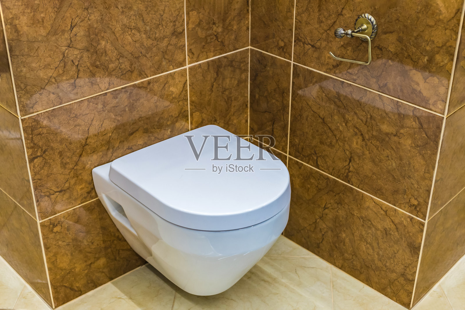 一个简单舒适的厕所，棕色的墙壁。方便的厕所在家里，机场，餐厅或咖啡馆。照片摄影图片