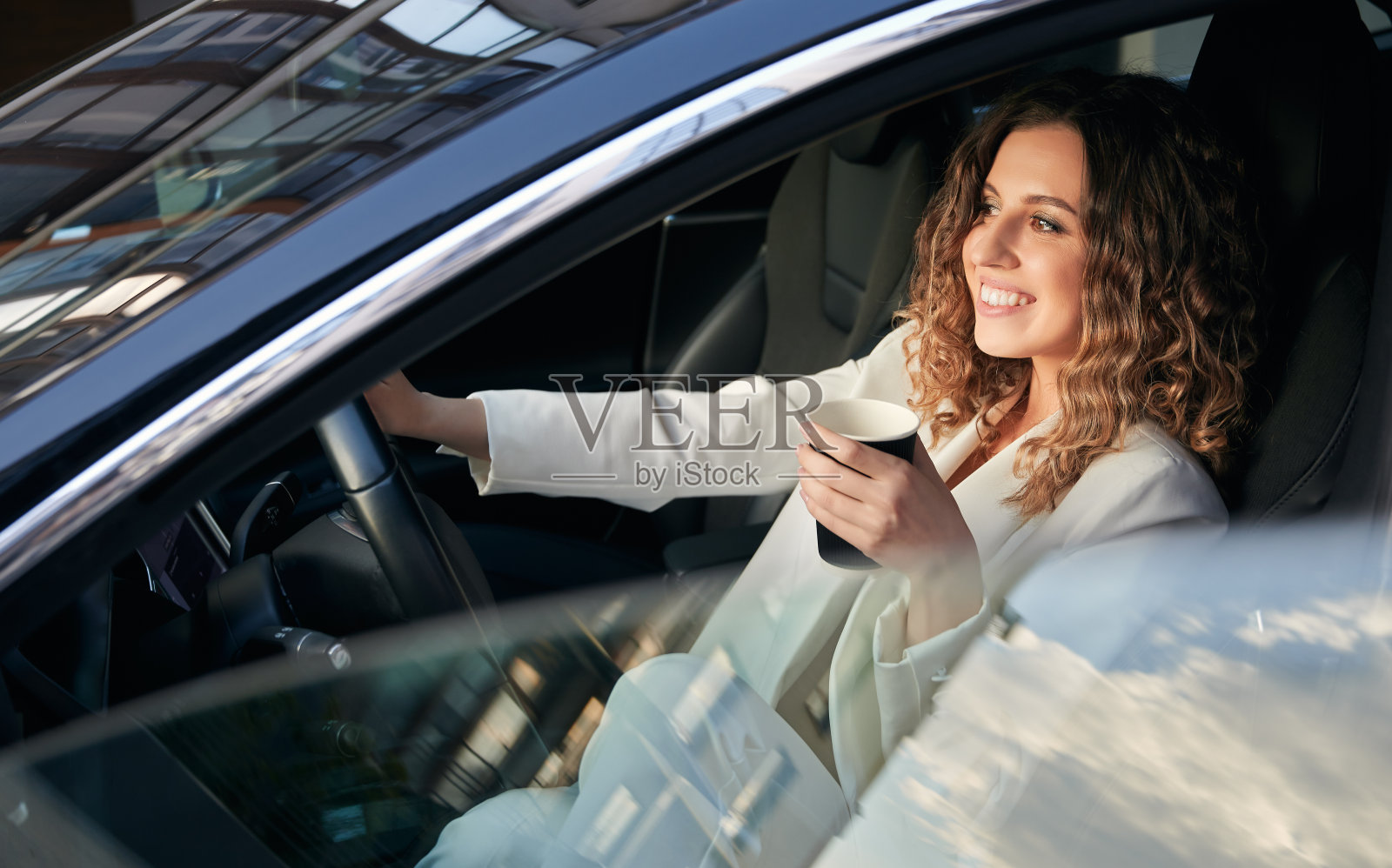 美丽的女商人开车喝咖啡。照片摄影图片