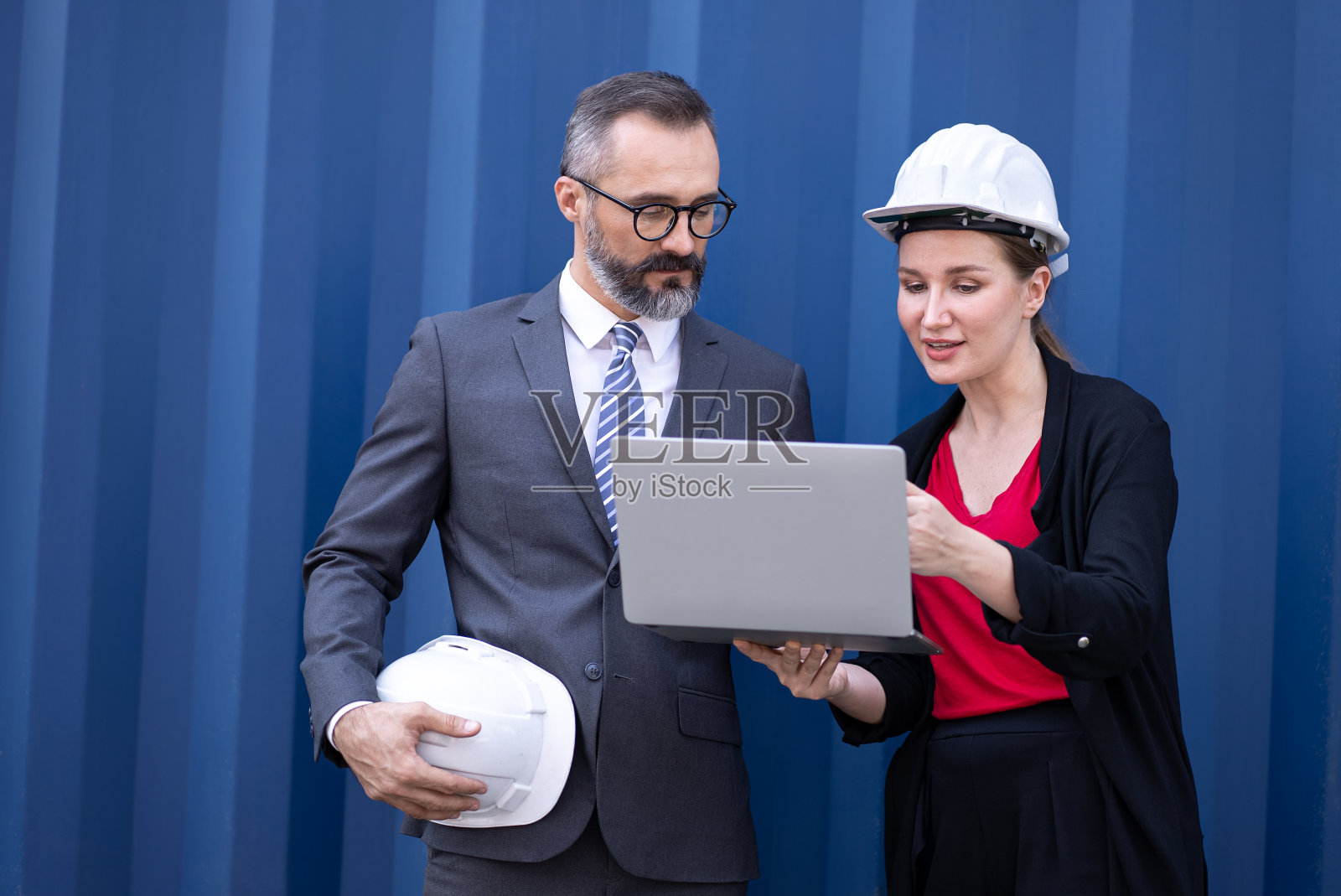 高级经理商人和女商人拿着笔记本电脑与蓝色集装箱船照片摄影图片