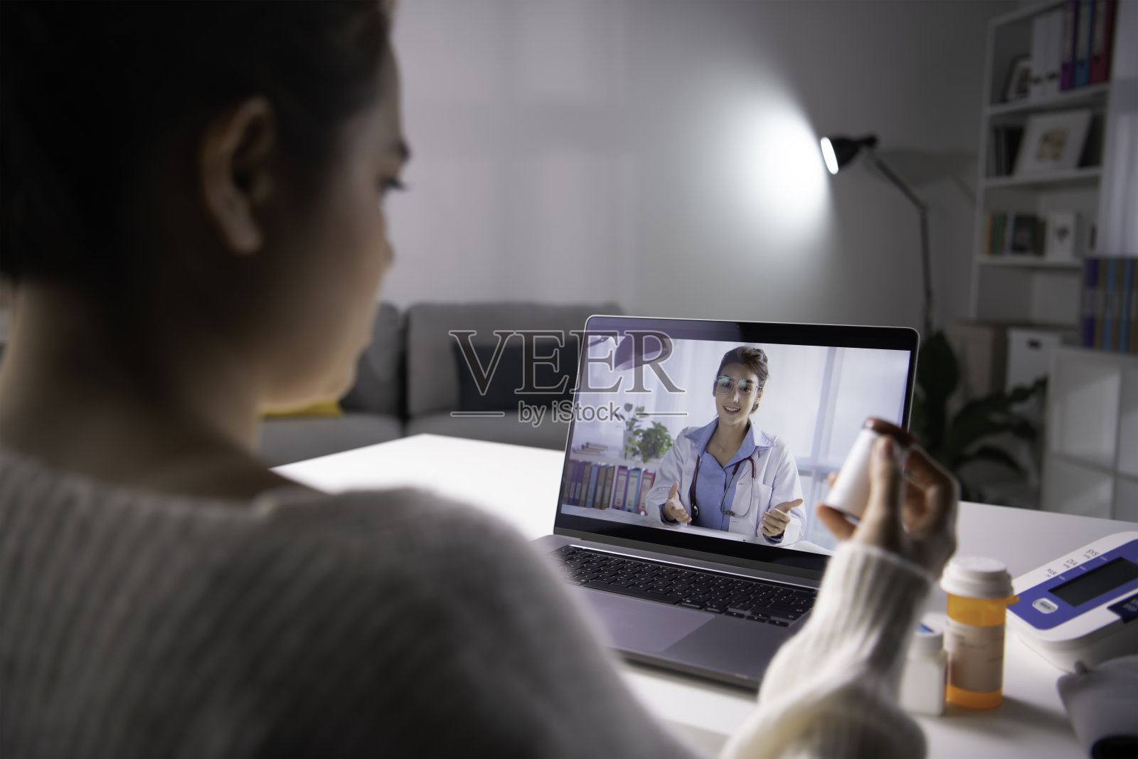 亚洲女患者在电脑上的网络摄像头会议上与医生在线交谈咨询。照片摄影图片