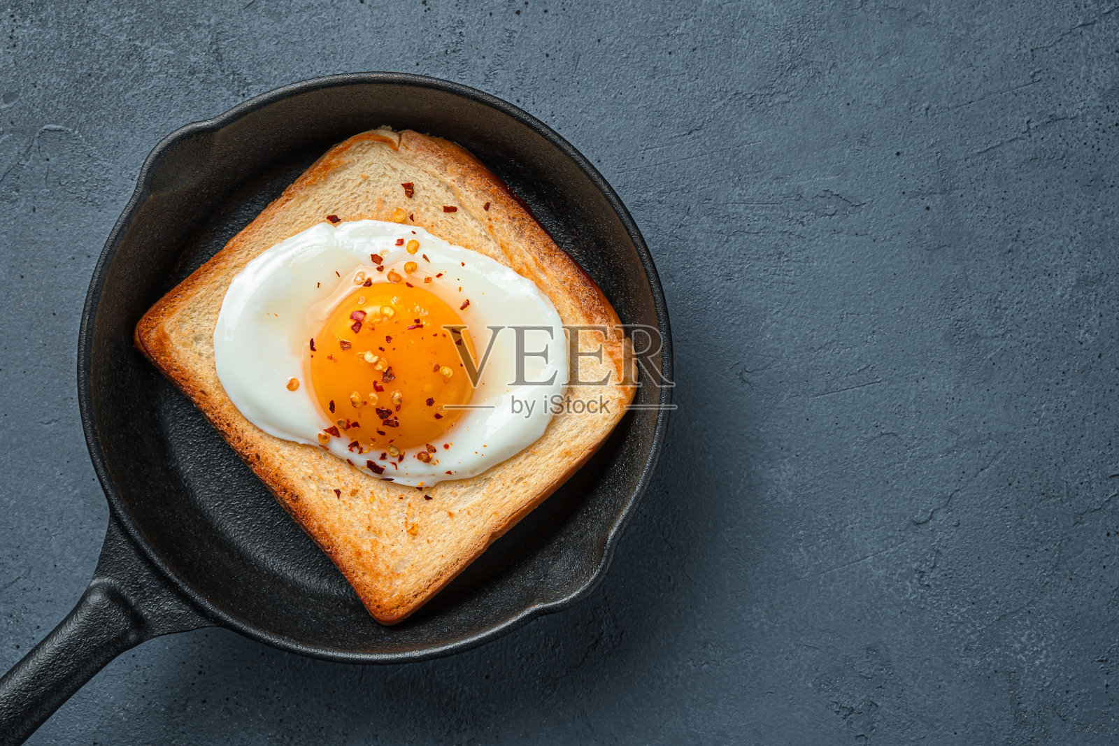 在黑色的背景上用煎锅煎鸡蛋照片摄影图片