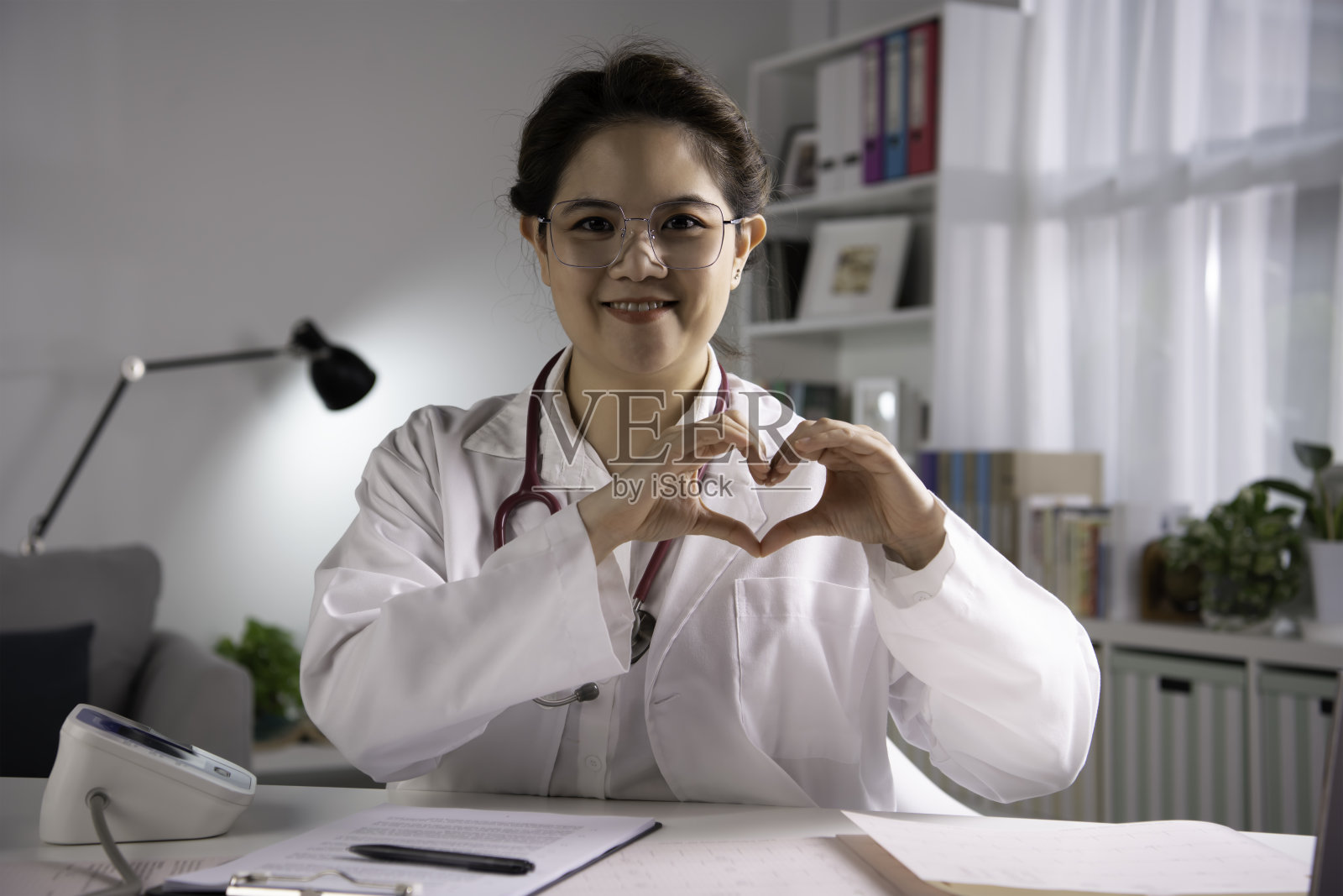 亚洲女医生与病人进行网上会诊做心脏标志。进行视频通话照片摄影图片